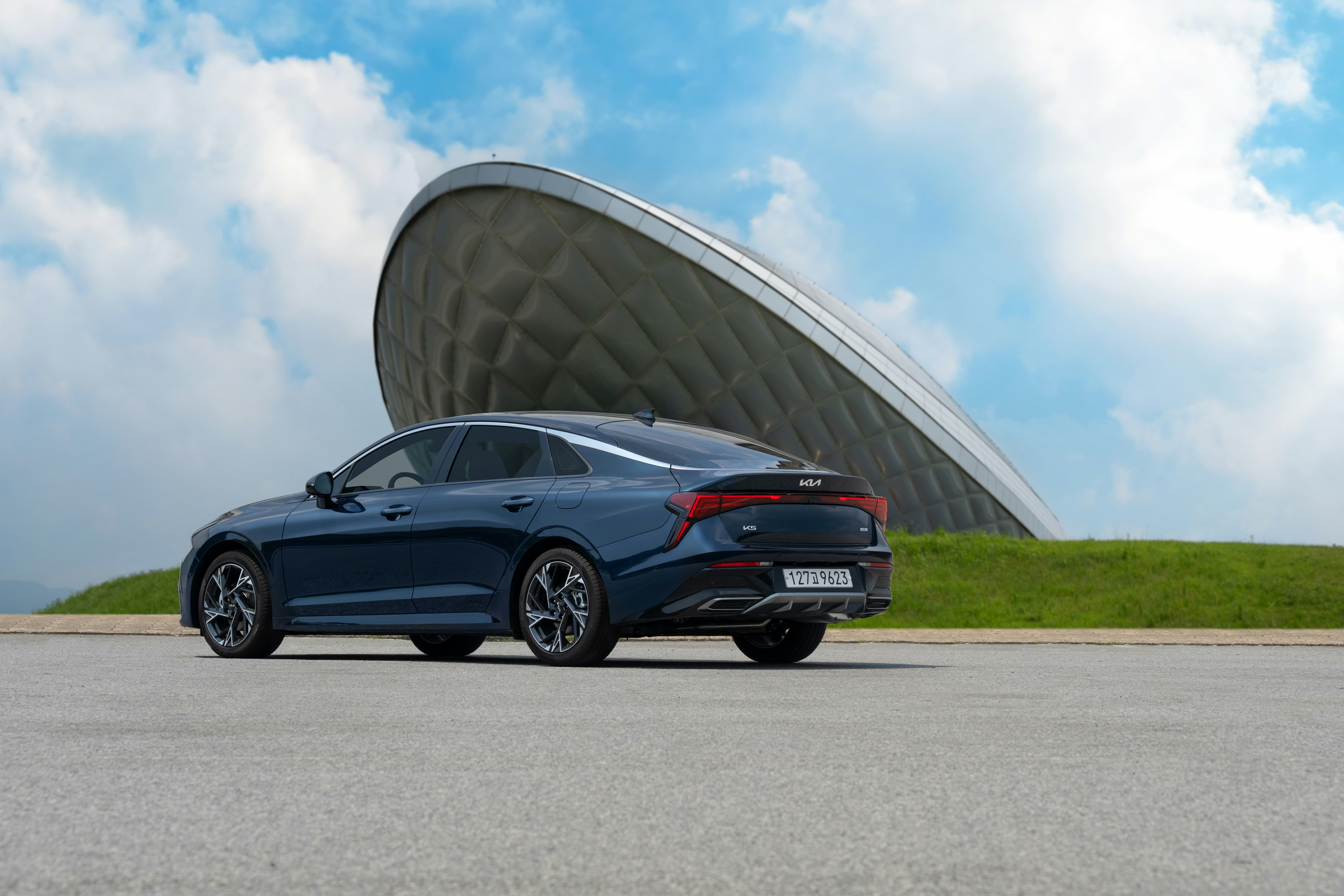 Dark blue car parked in front of modern building