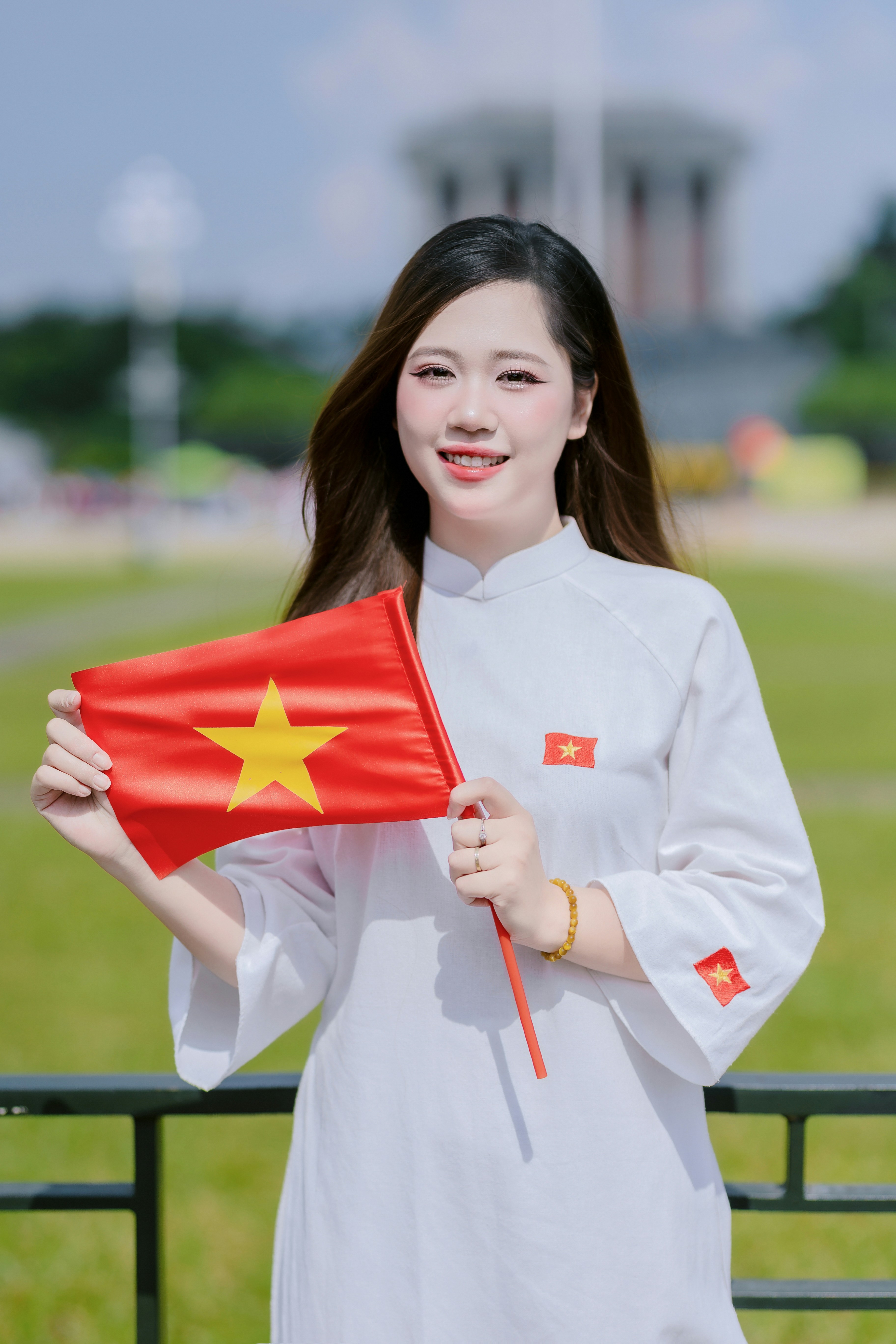 Young woman holding vietnamese flag outdoors