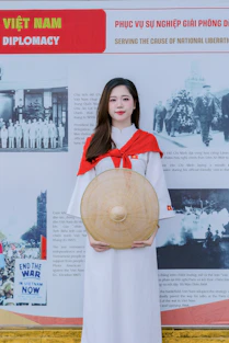 Young woman in traditional vietnamese clothing holding a conical hat