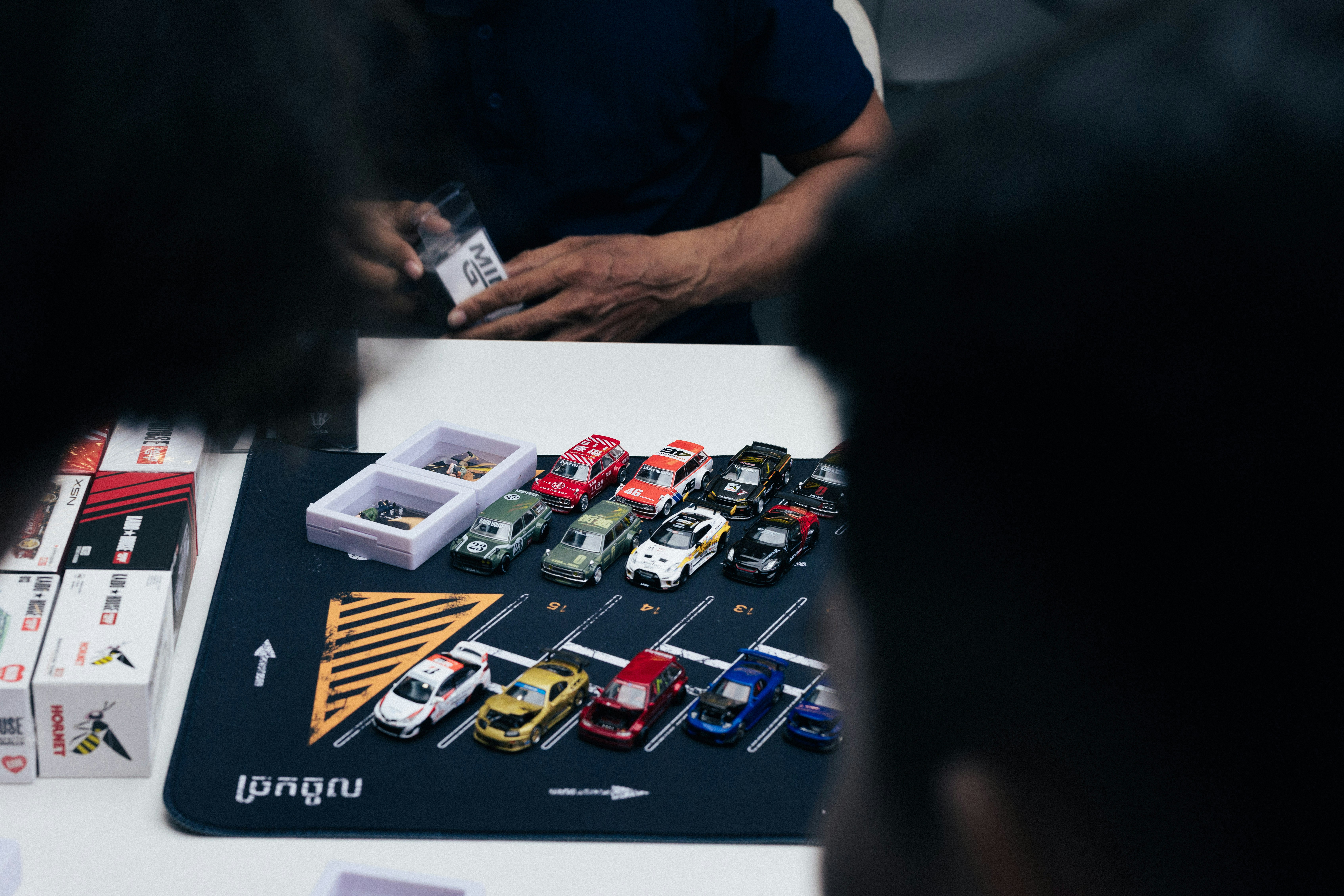 People looking at a table with many small items.