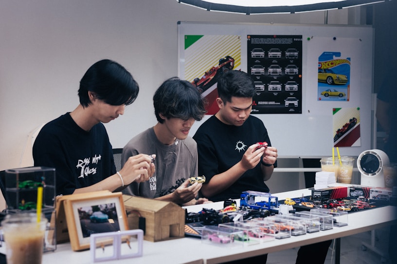 Three people focused on a table with items