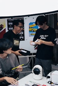 Three people looking at something on a table.