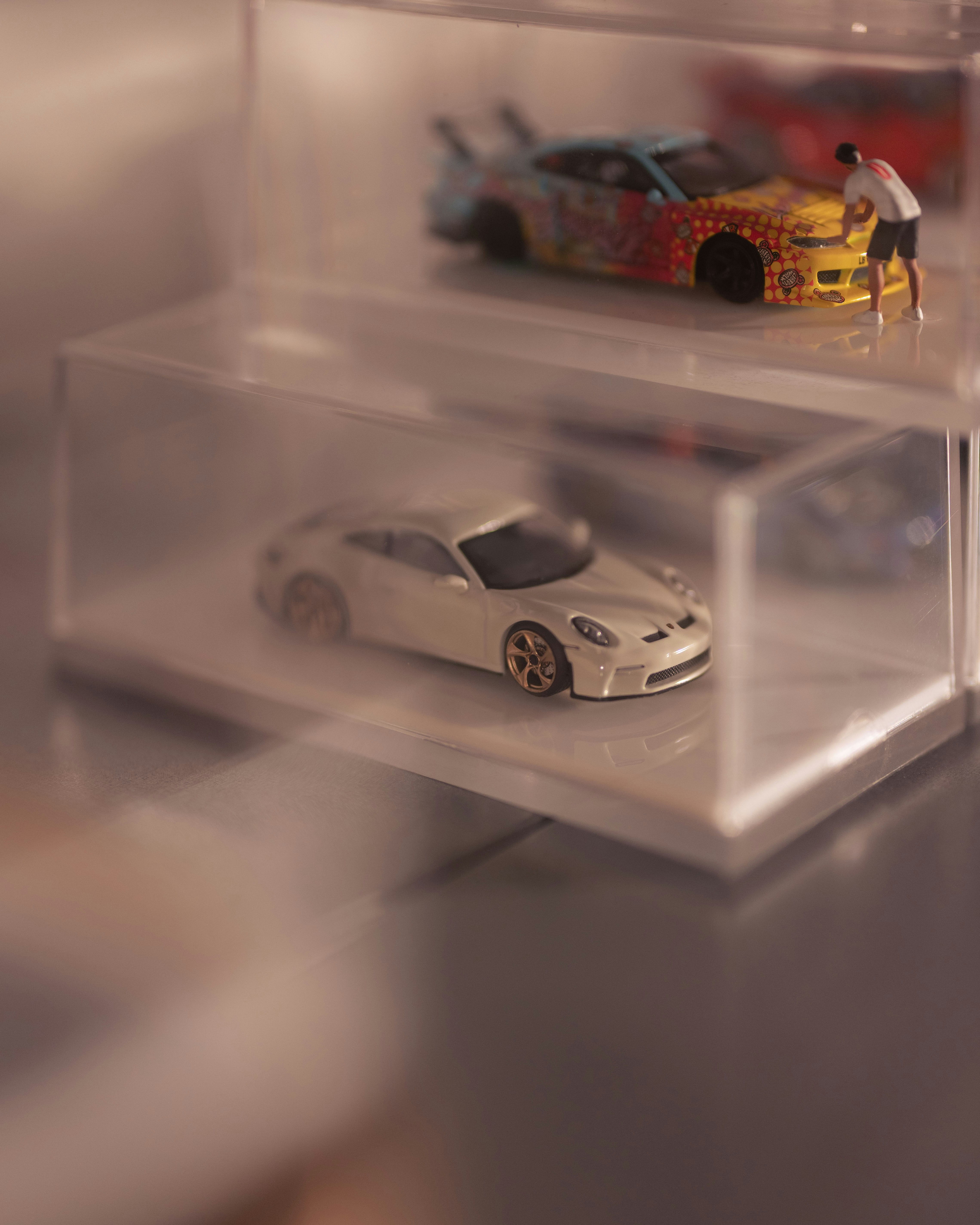 Two toy cars displayed in clear plastic cases.