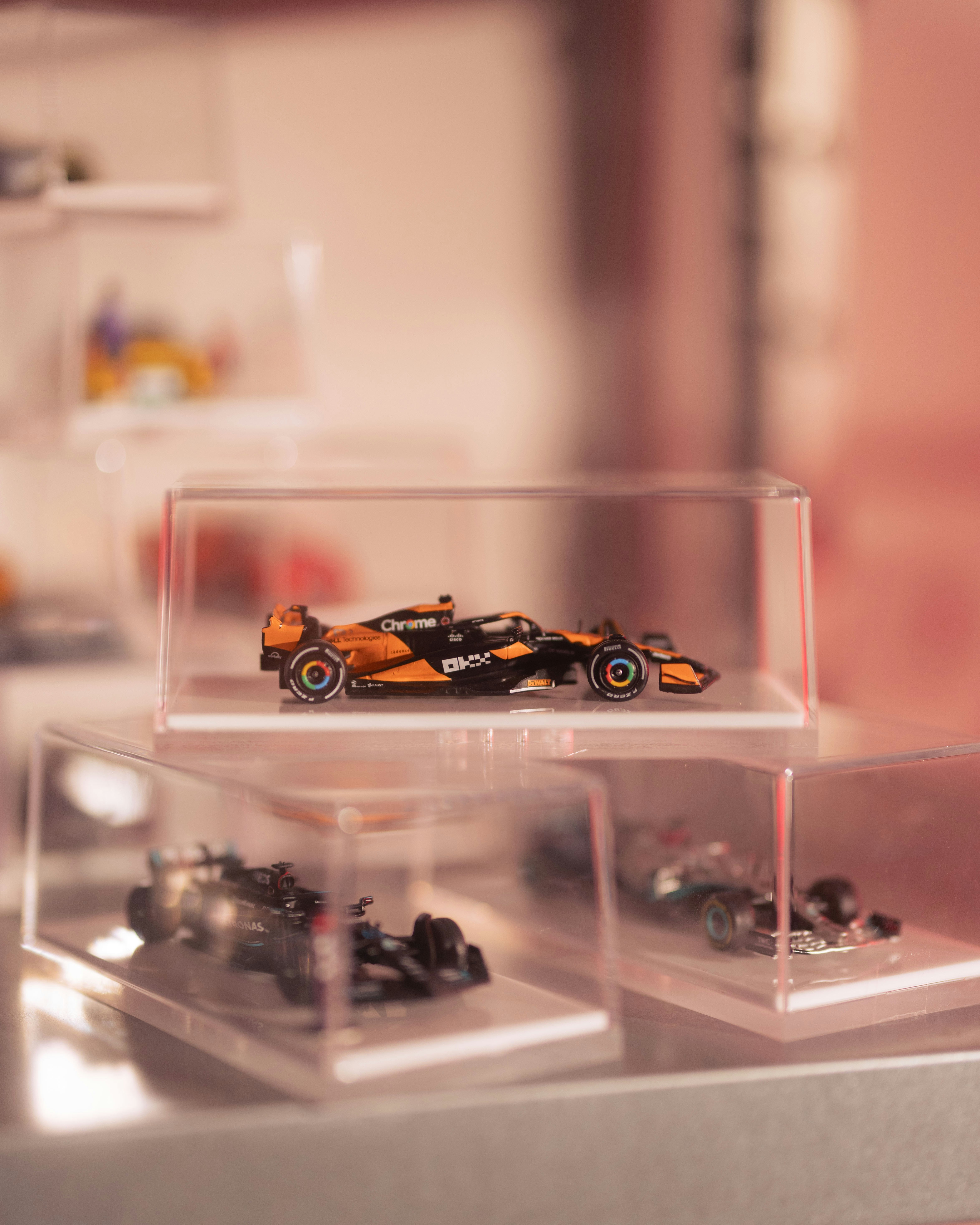 Model race cars displayed in clear cases
