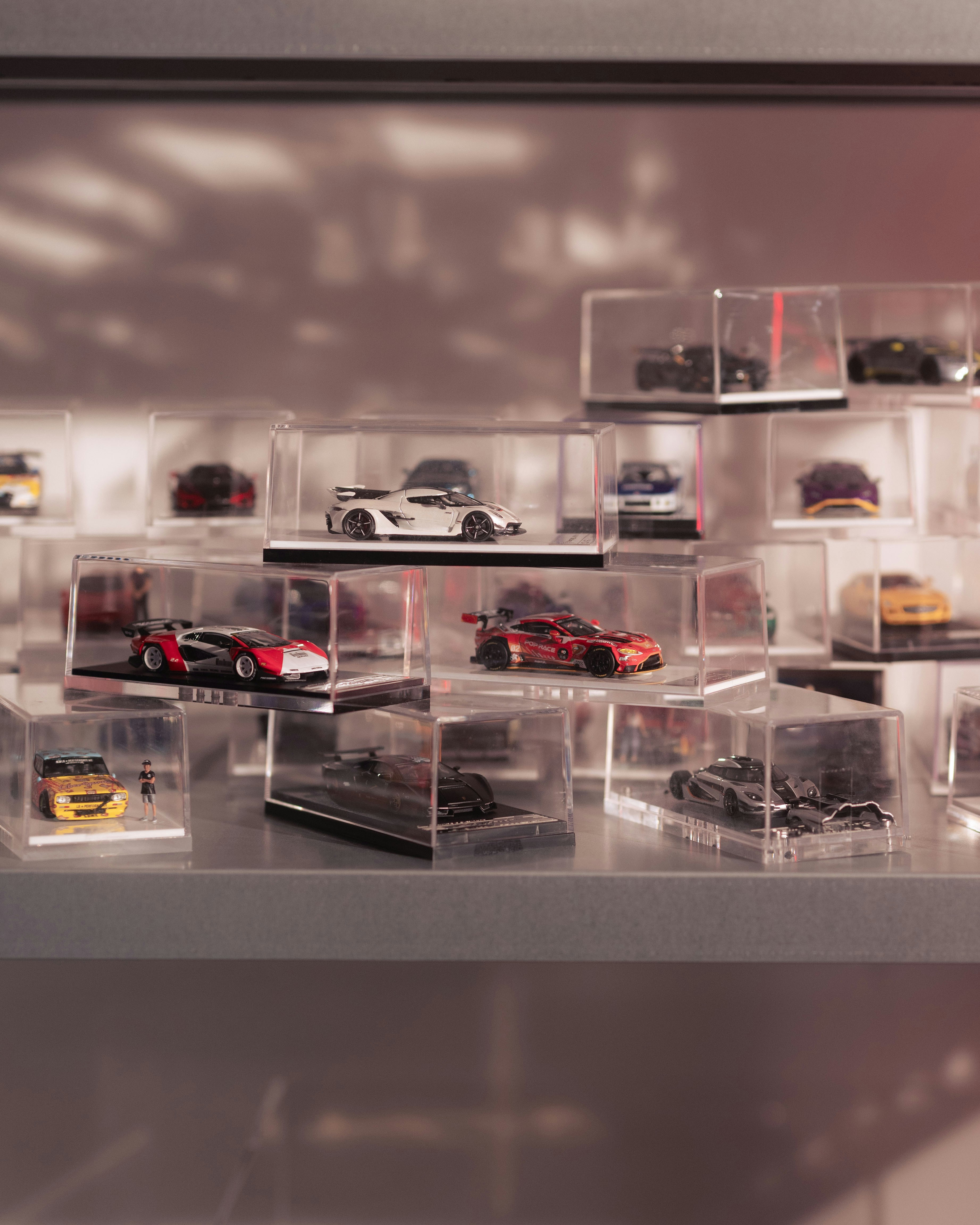 Collection of model cars displayed in clear cases