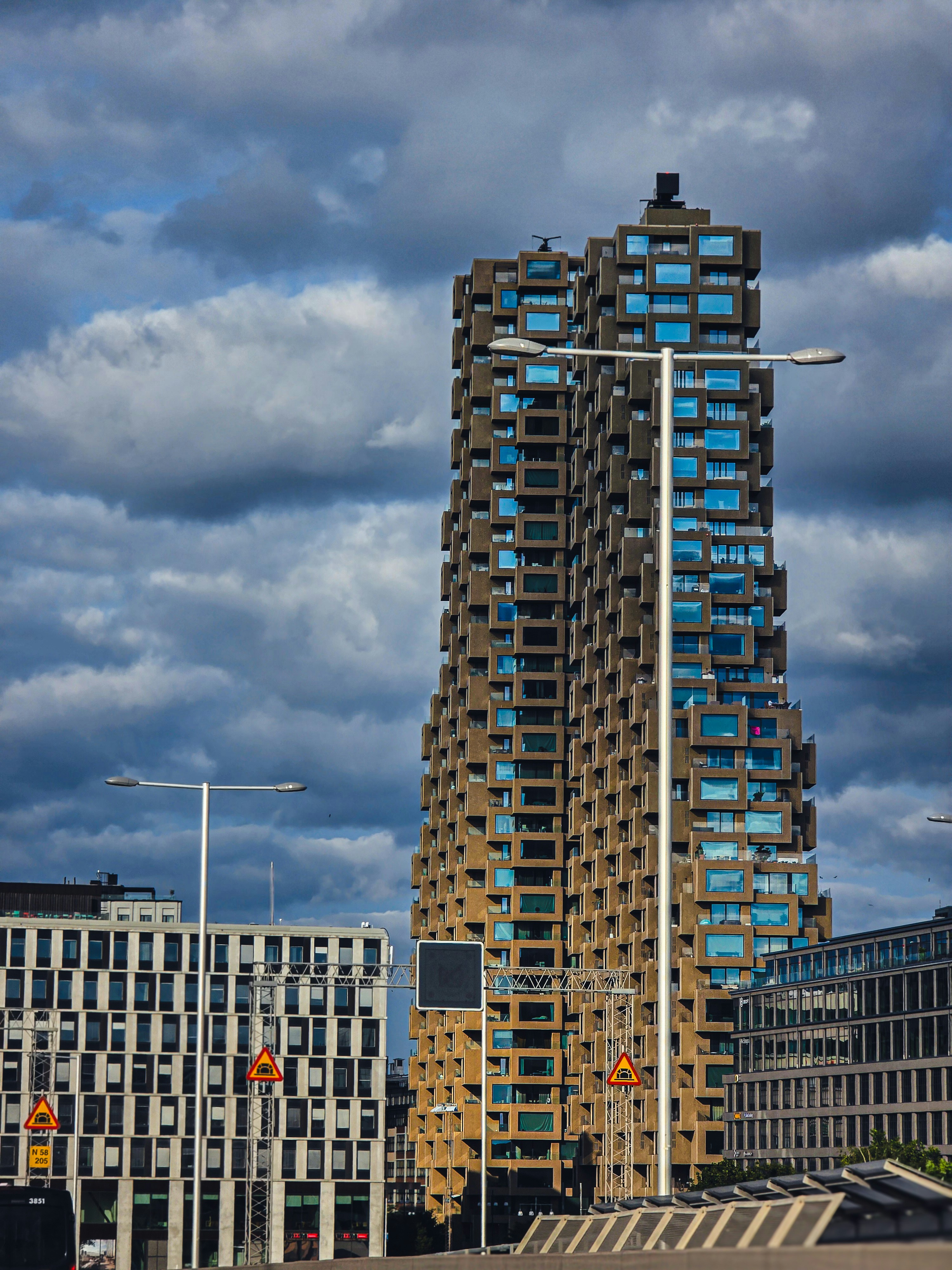 Modern skyscraper against a dramatic cloudy sky.