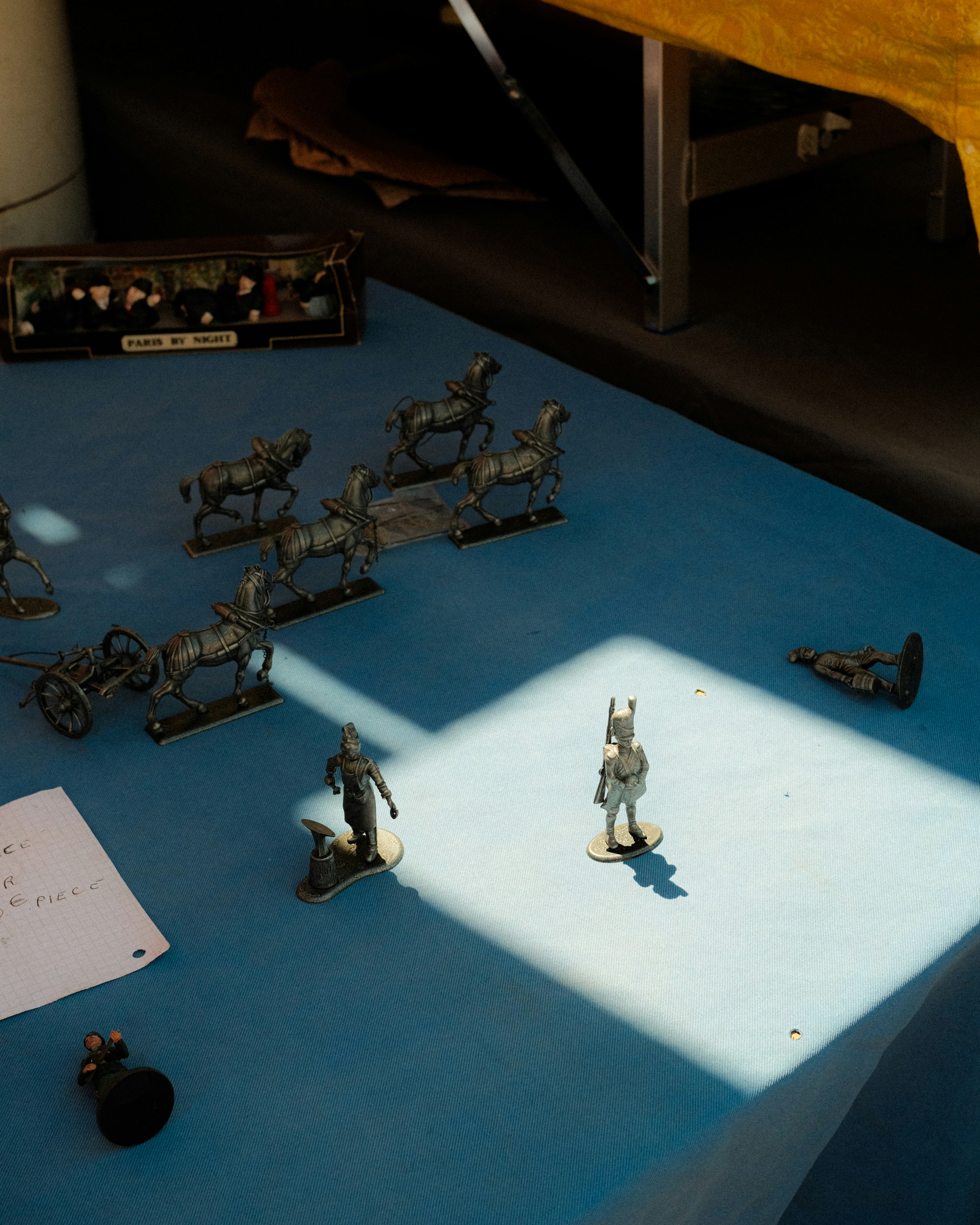 Miniature soldiers and chariots displayed on a blue surface.