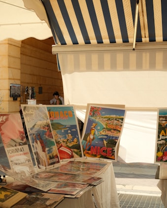 Vintage travel posters displayed at an outdoor market.