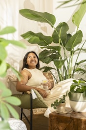 Woman relaxing among lush green houseplants