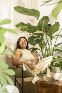 Woman relaxing among lush green houseplants