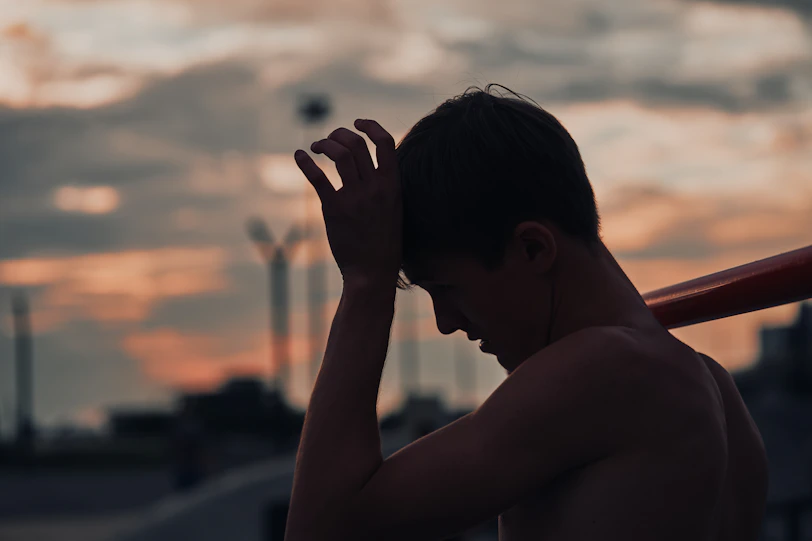 Silhouette of a tired baseball player with bat at sunset