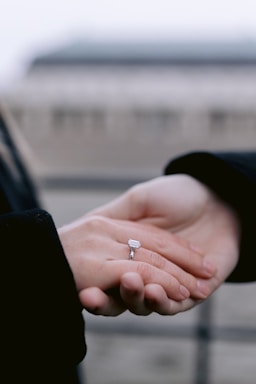 Hands exchanging a small object outdoors