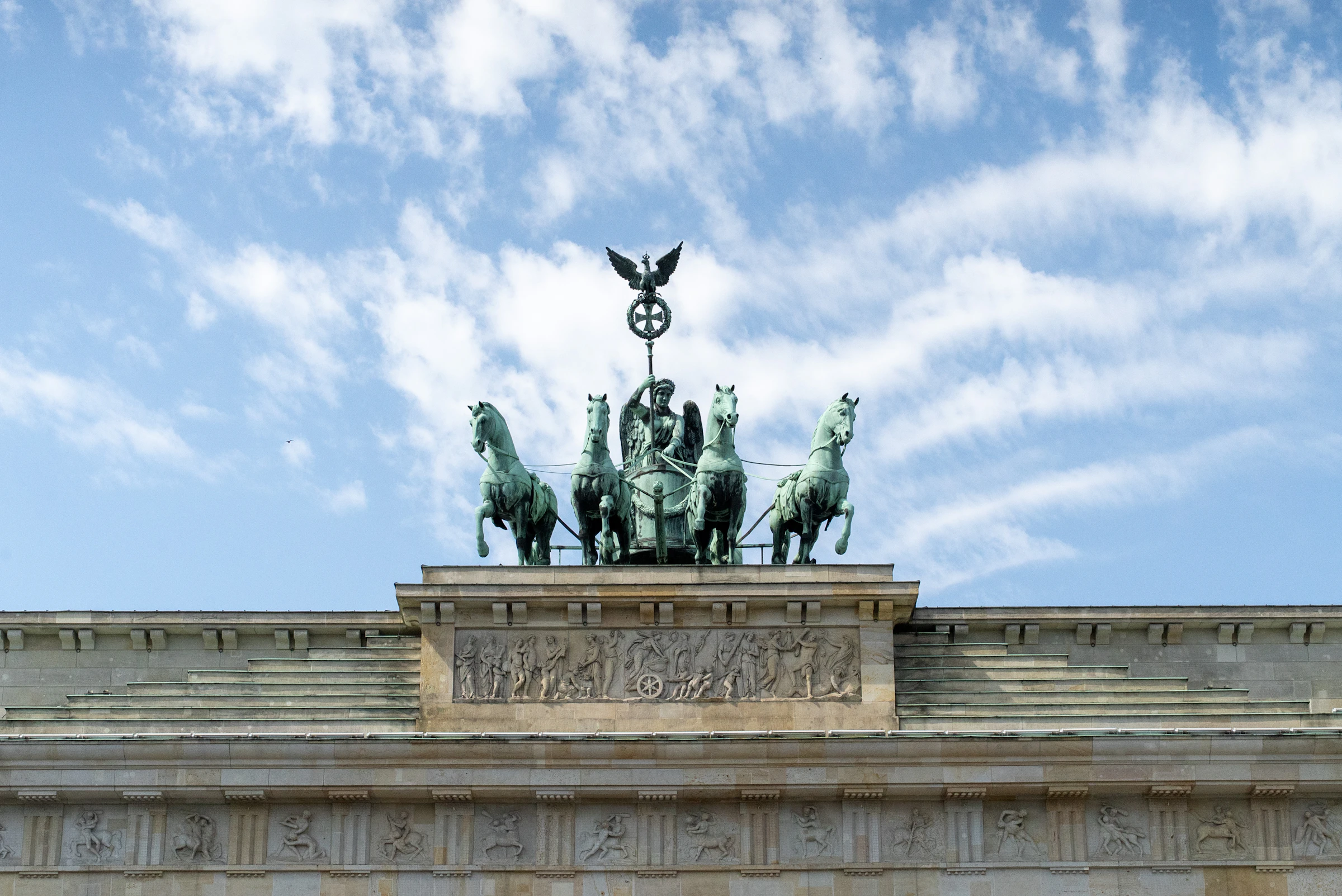 The Brandenburg Gate in Berlin, Germany under a bright blue sky