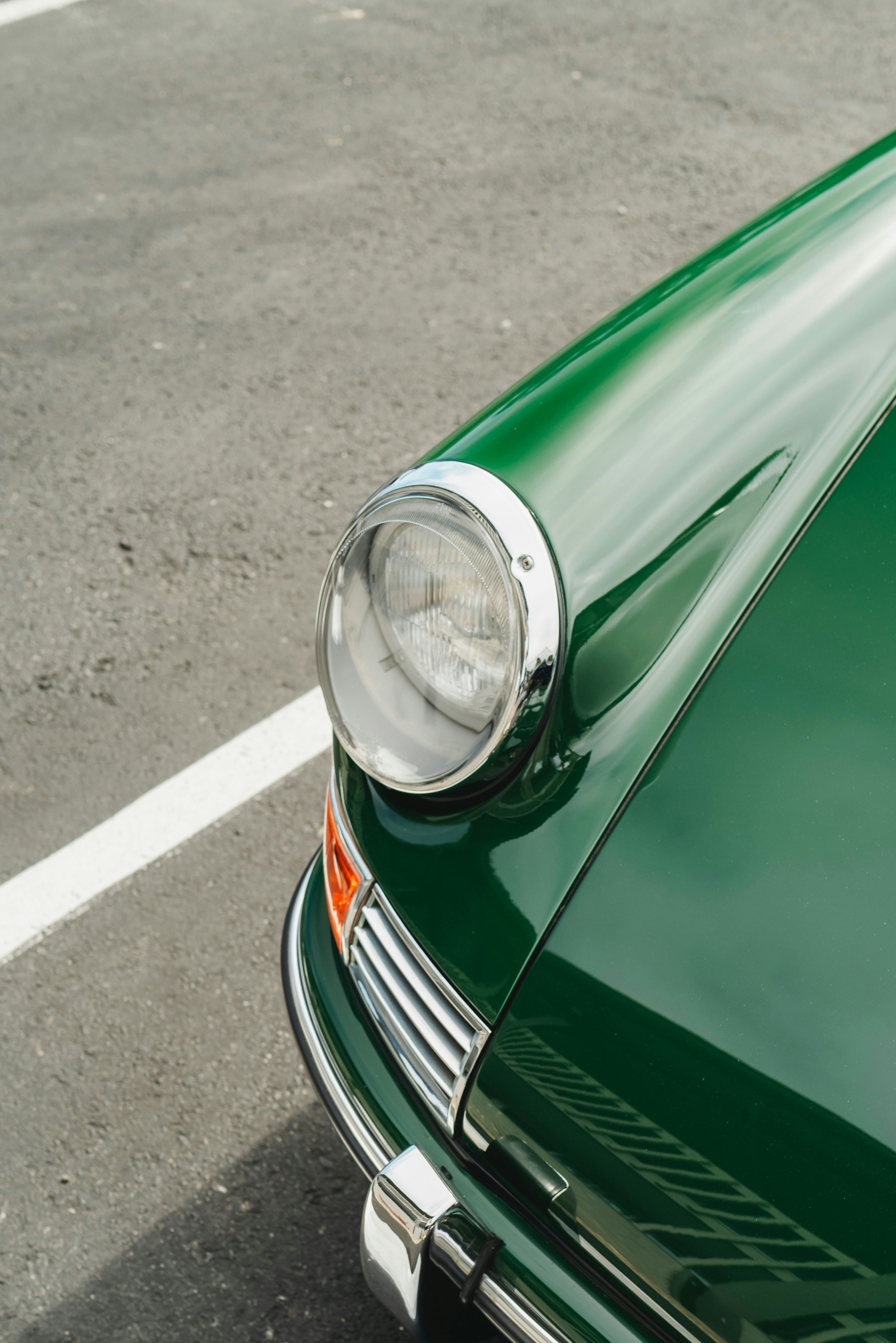 Close-up of a vintage green car's headlight