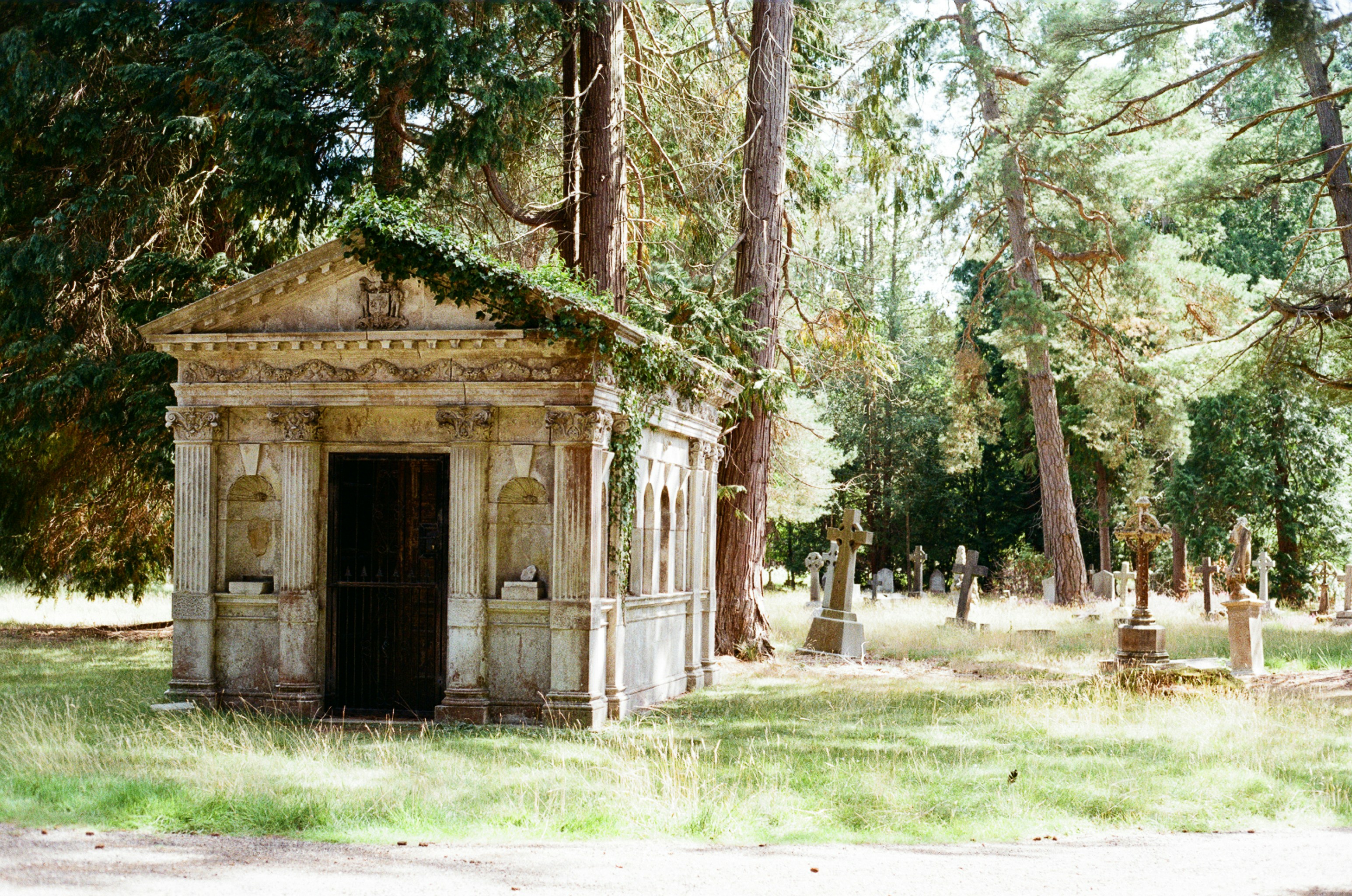 Mausolée en pierre ornée dans un cimetière boisé
