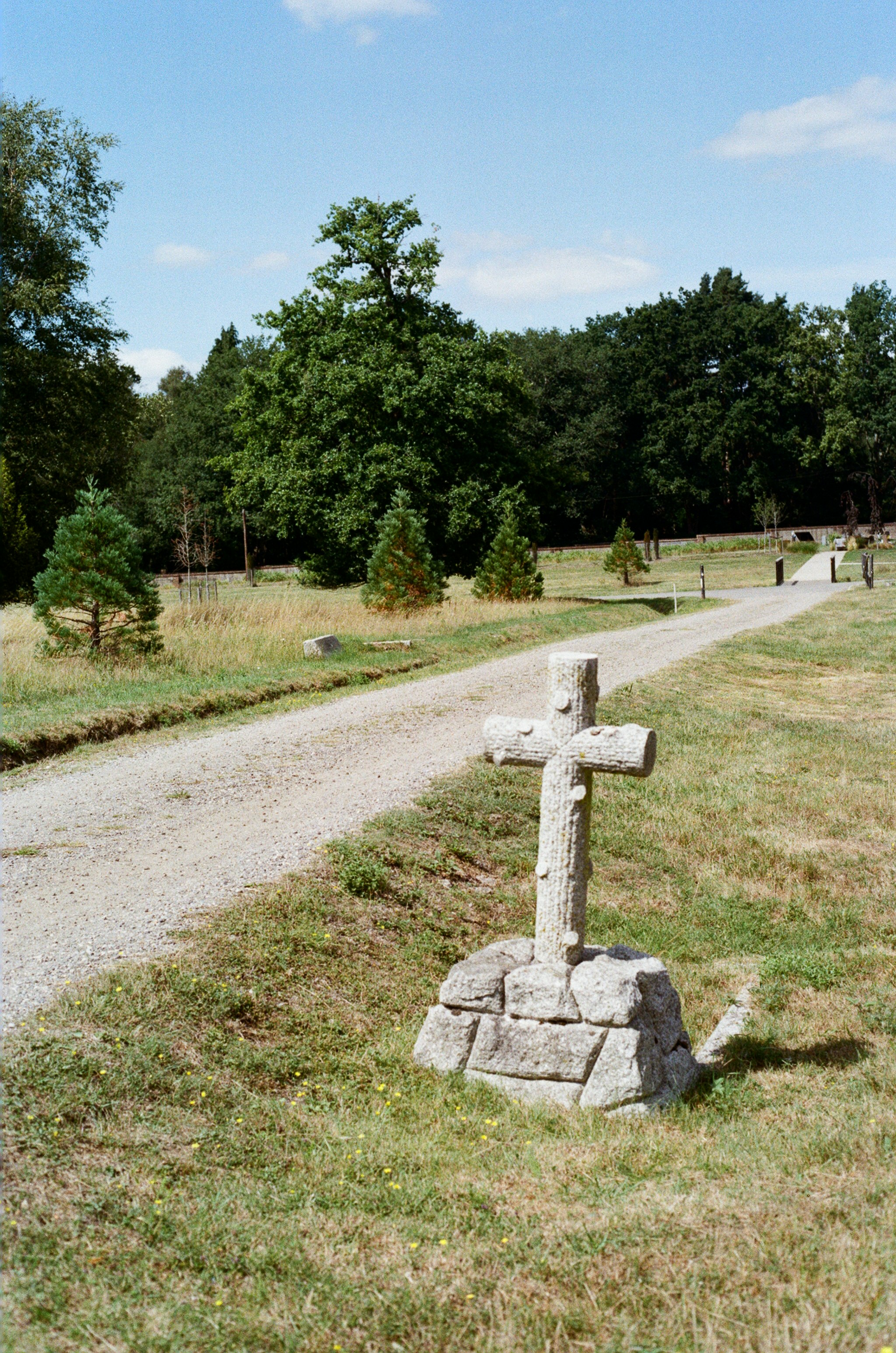 Stone cross on a path in a grassy field