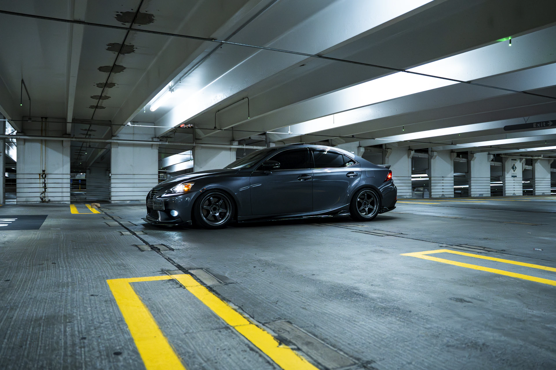 Dark car driving through a parking garage.