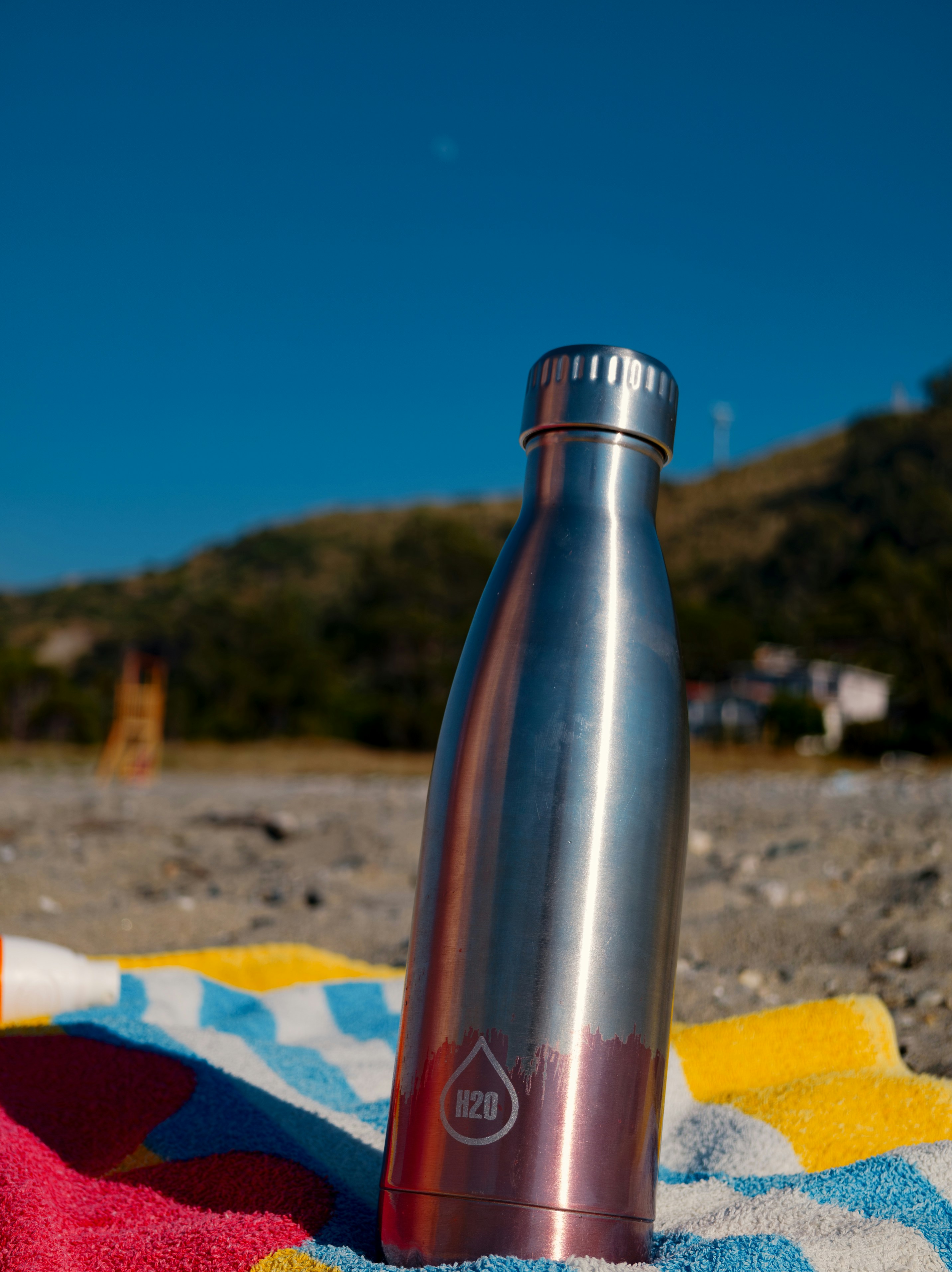 Stainless steel water bottle on beach towel