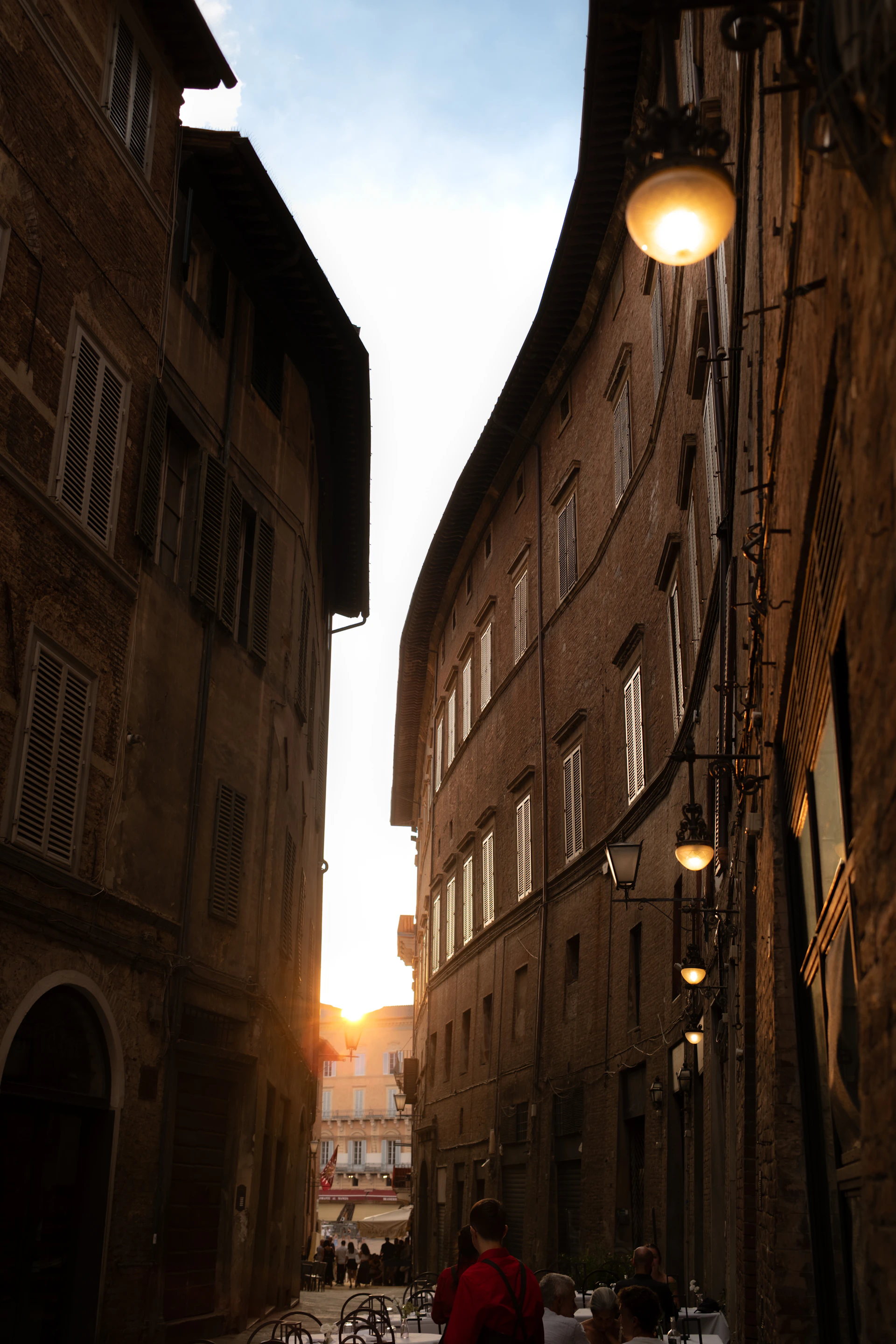 Narrow european street with buildings and sunset