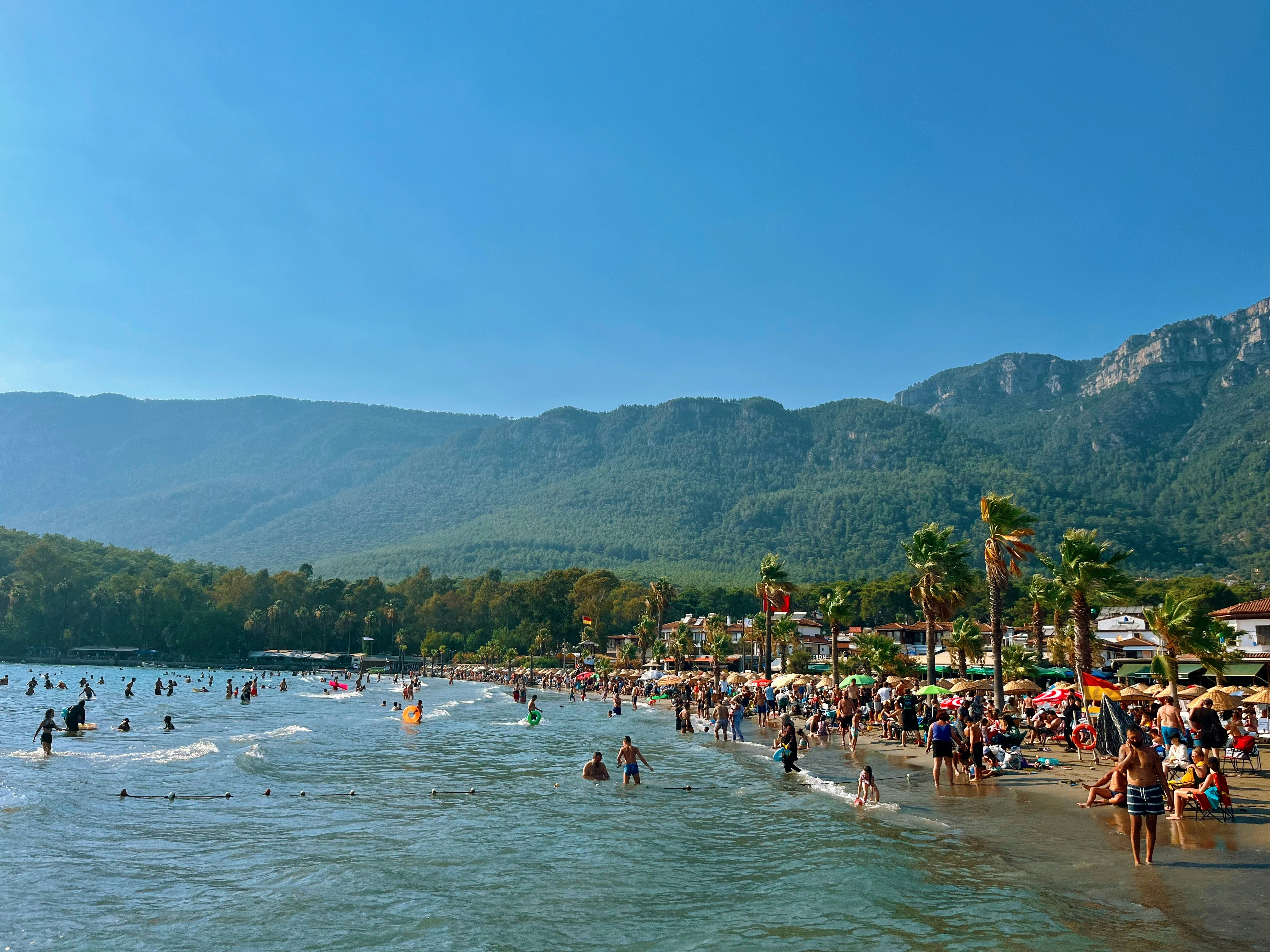 People enjoying a sunny day at a crowded beach.
