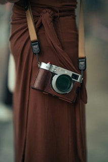 Woman wearing a brown dress with a camera