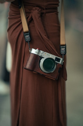 Woman wearing a brown dress with a camera