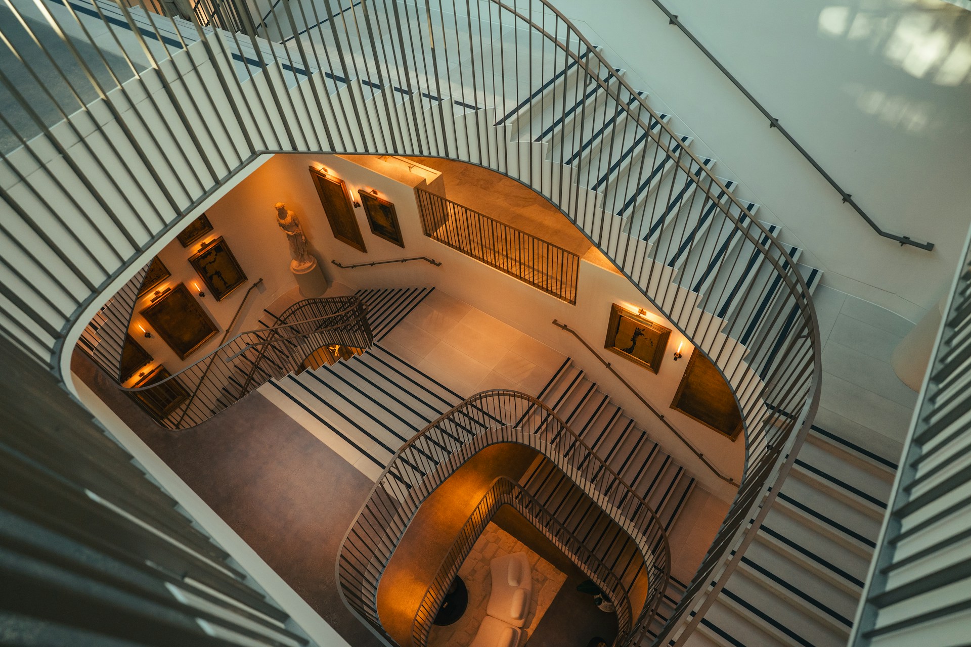 Modern spiral staircase with metal railings and artwork