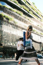 Woman crosses street in front of modern building