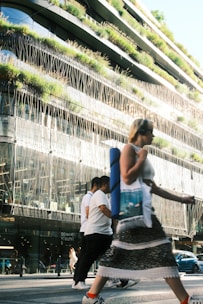 Woman crosses street in front of modern building