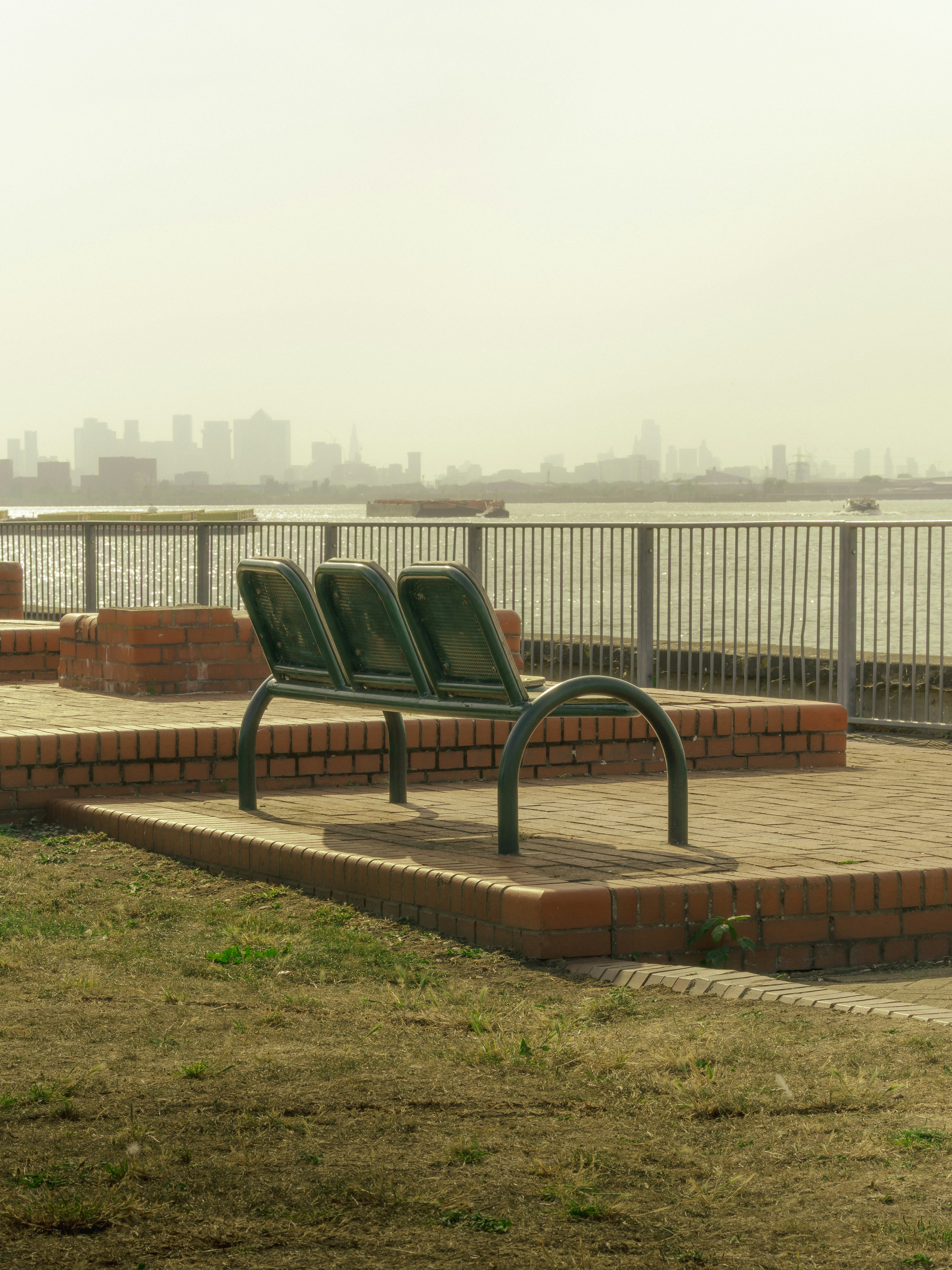 Trois bancs vides surplombent les toits brumeux de la ville