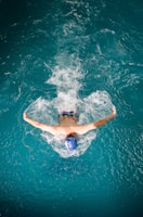 Swimmer performing butterfly stroke in blue water