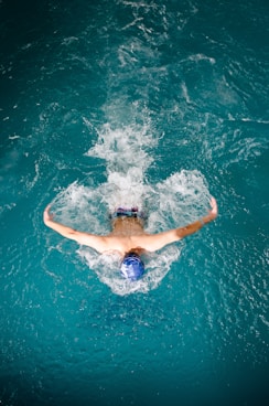 Swimmer performing butterfly stroke in blue water