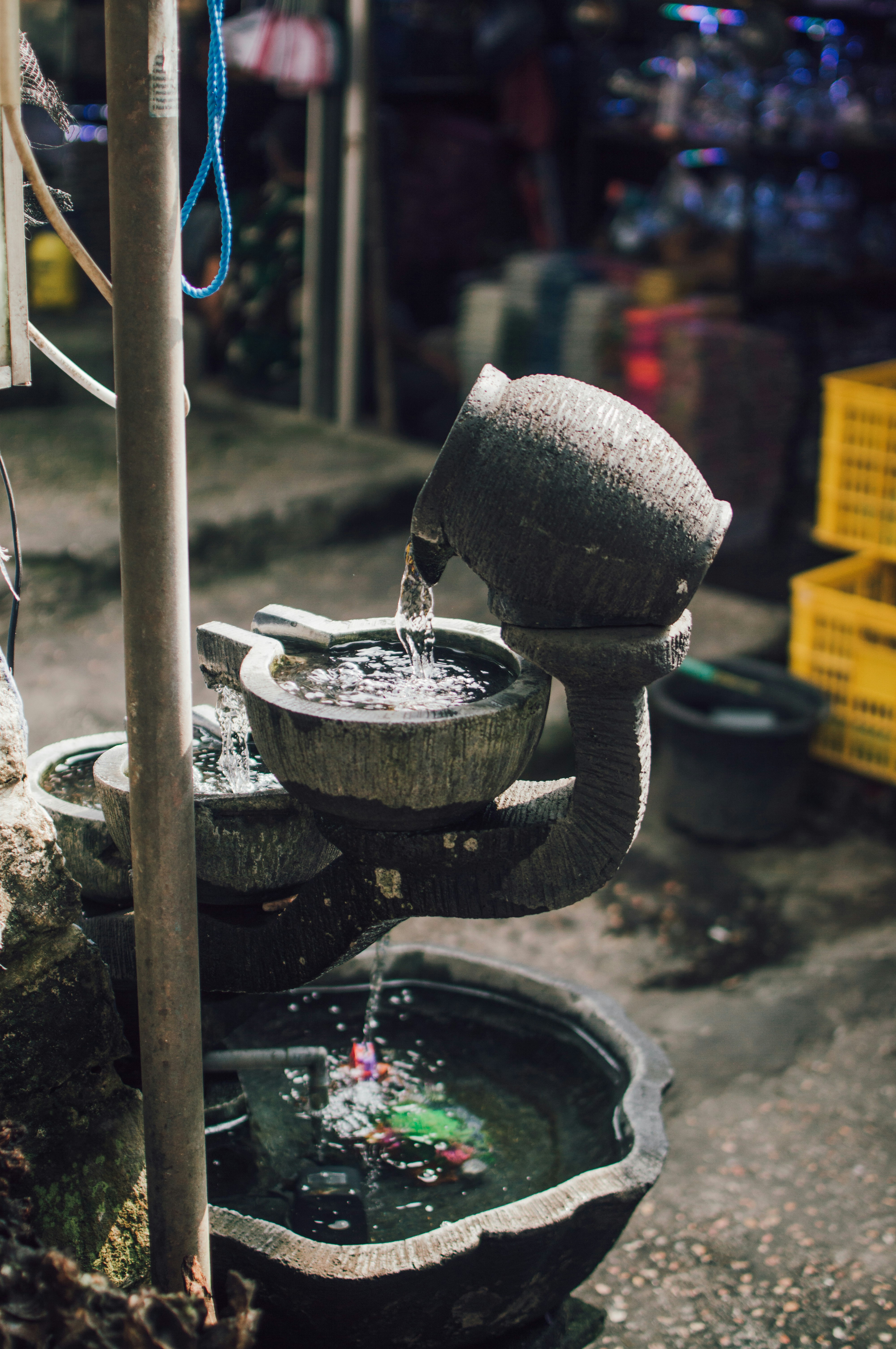 Water flows from a ceramic pot into basins.