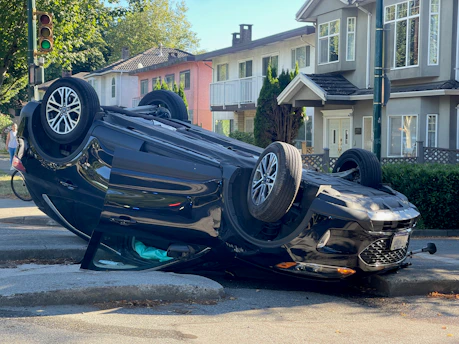 A car overturned on its side on a street