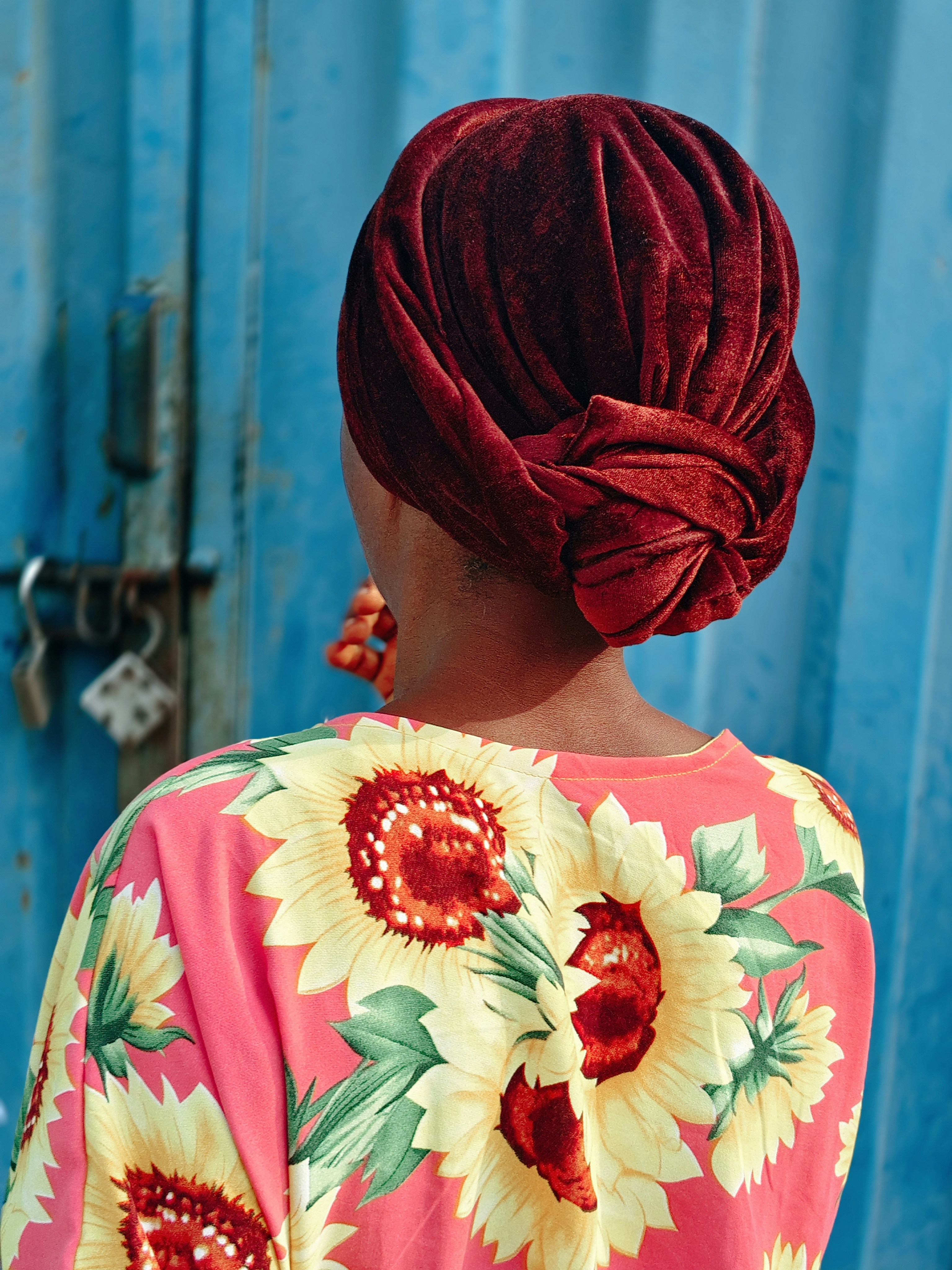 Woman with red headwrap and sunflower dress