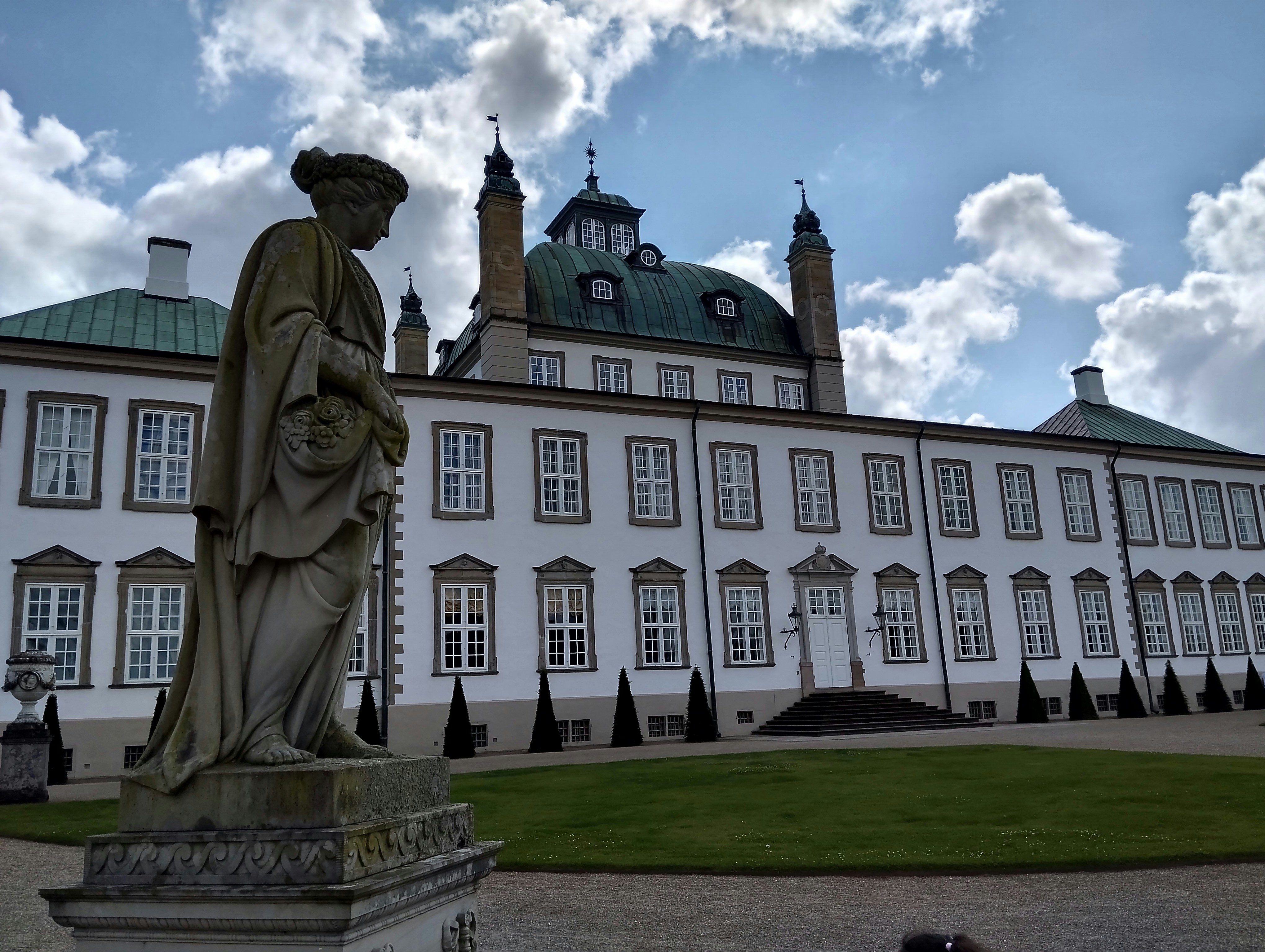 Statue in front of a grand white palace
