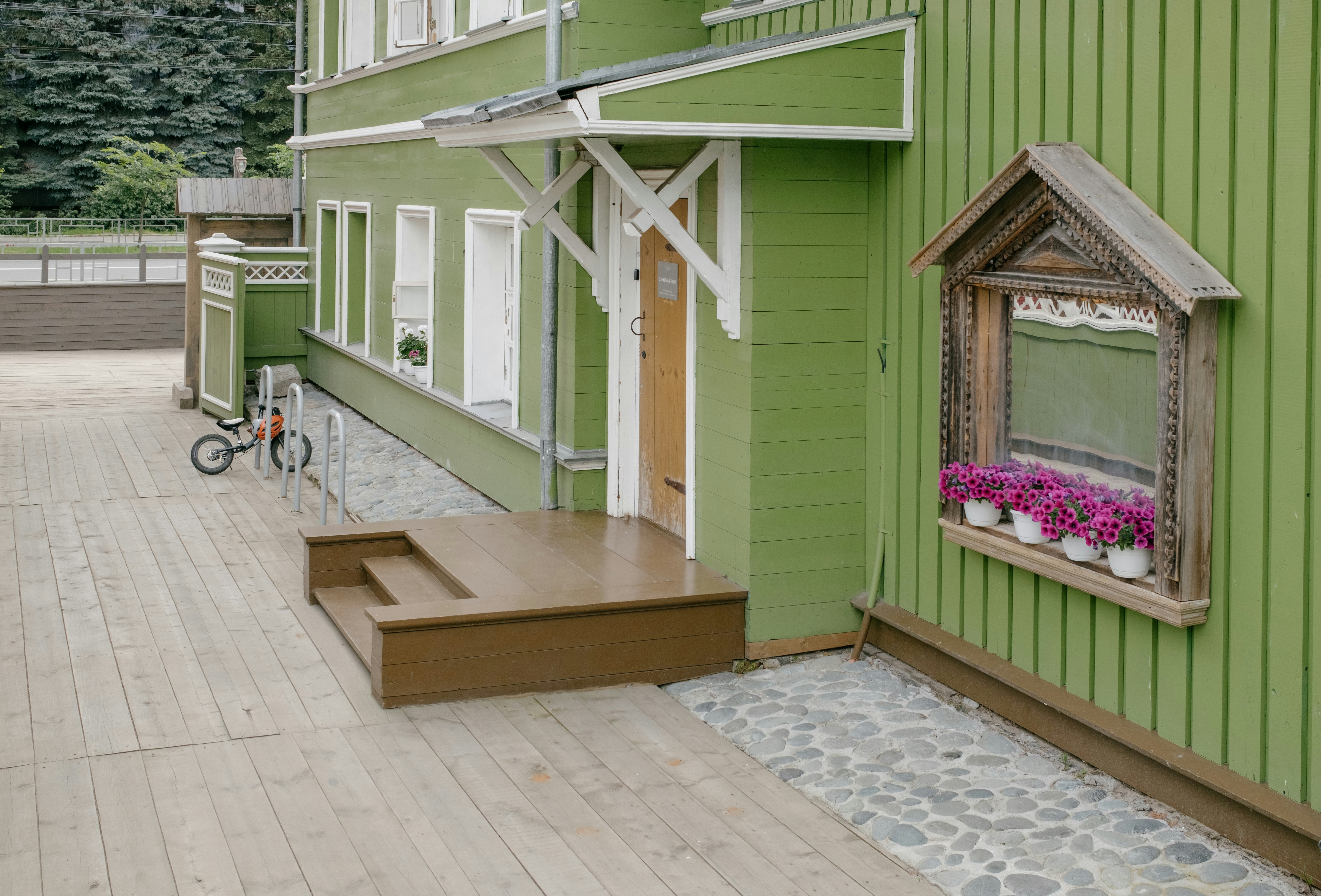 Green wooden house with flower box window