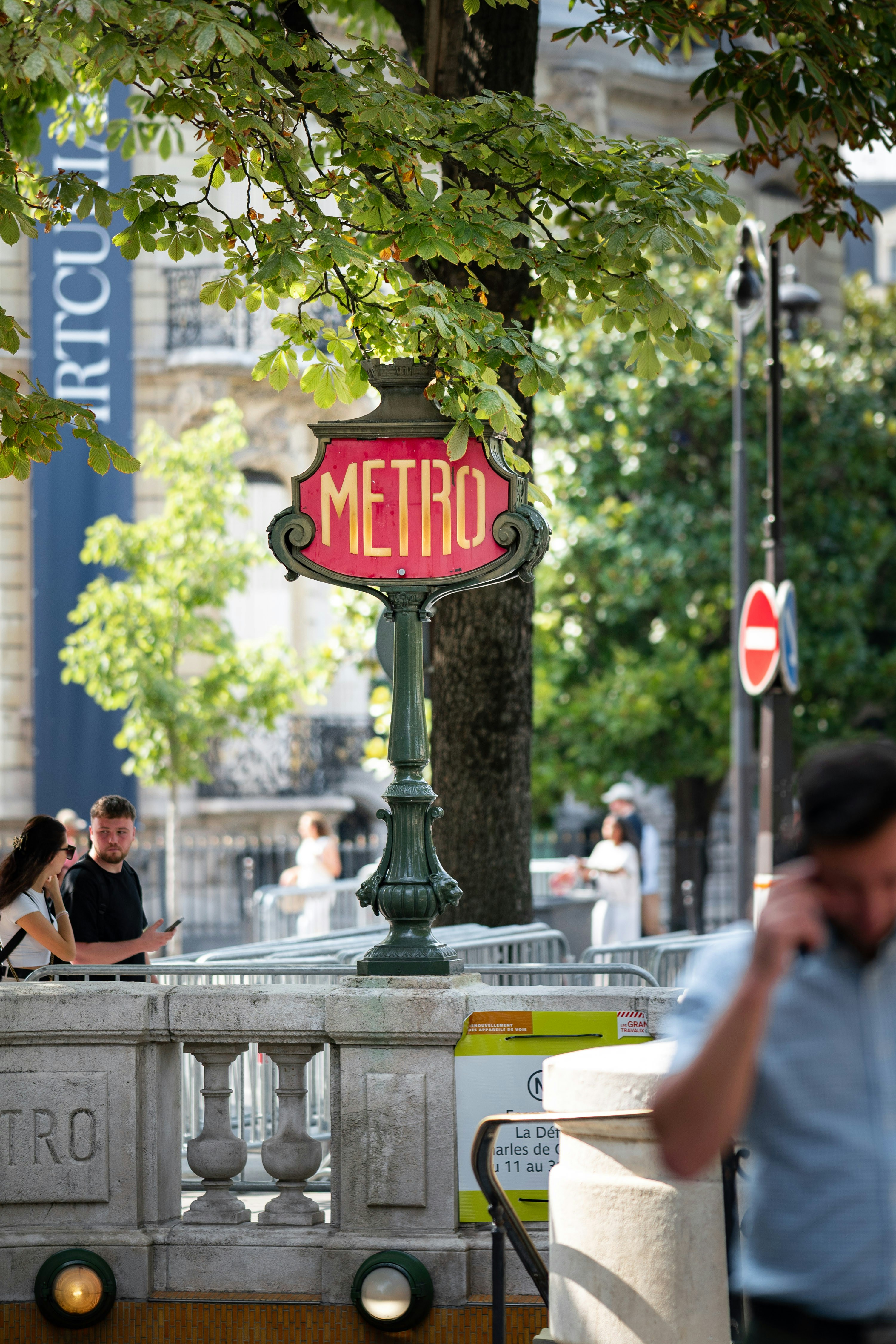 panneau du métro de Paris avec des personnes en arrière-plan
