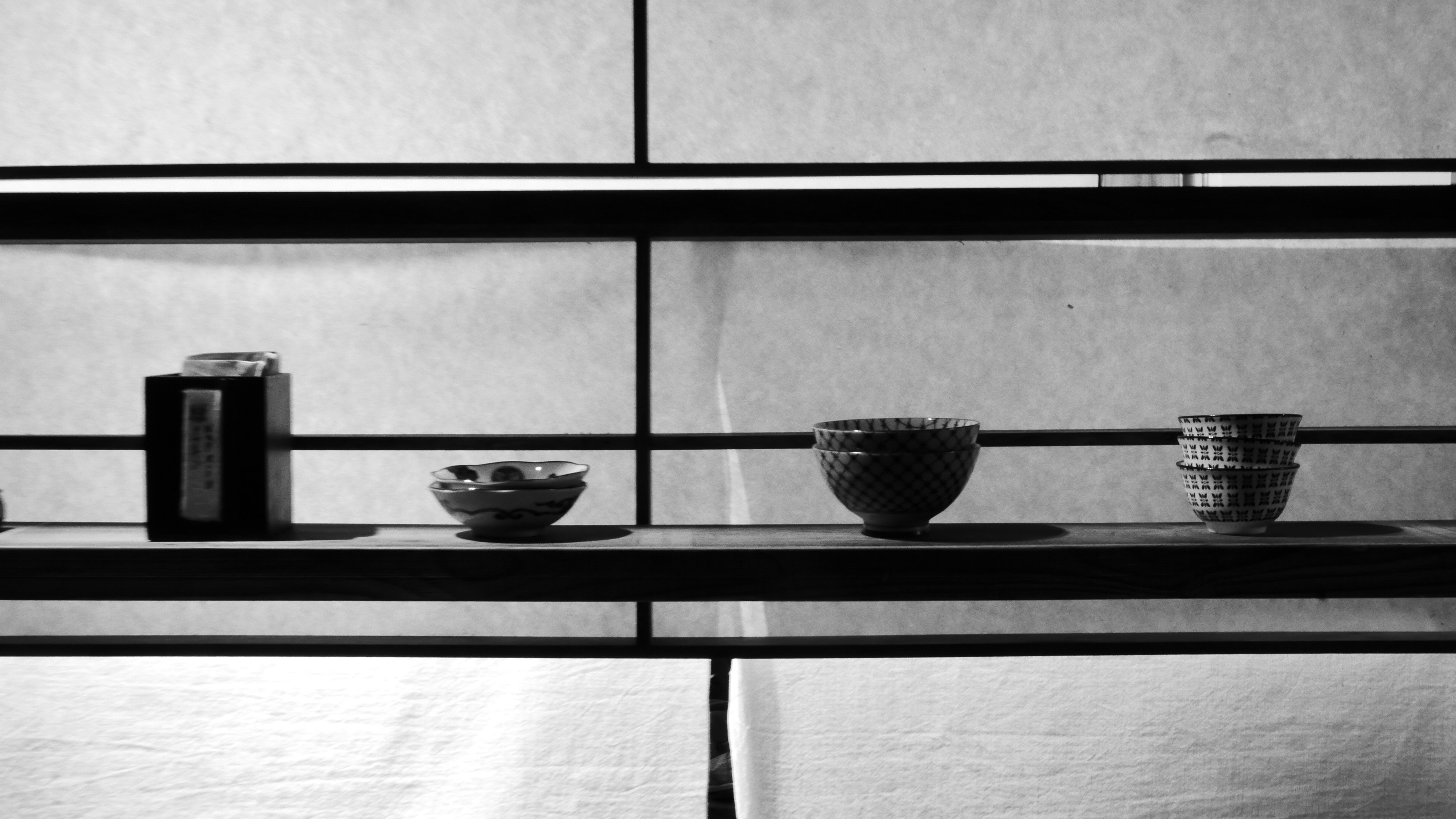 Four objects arranged on shelves in black and white