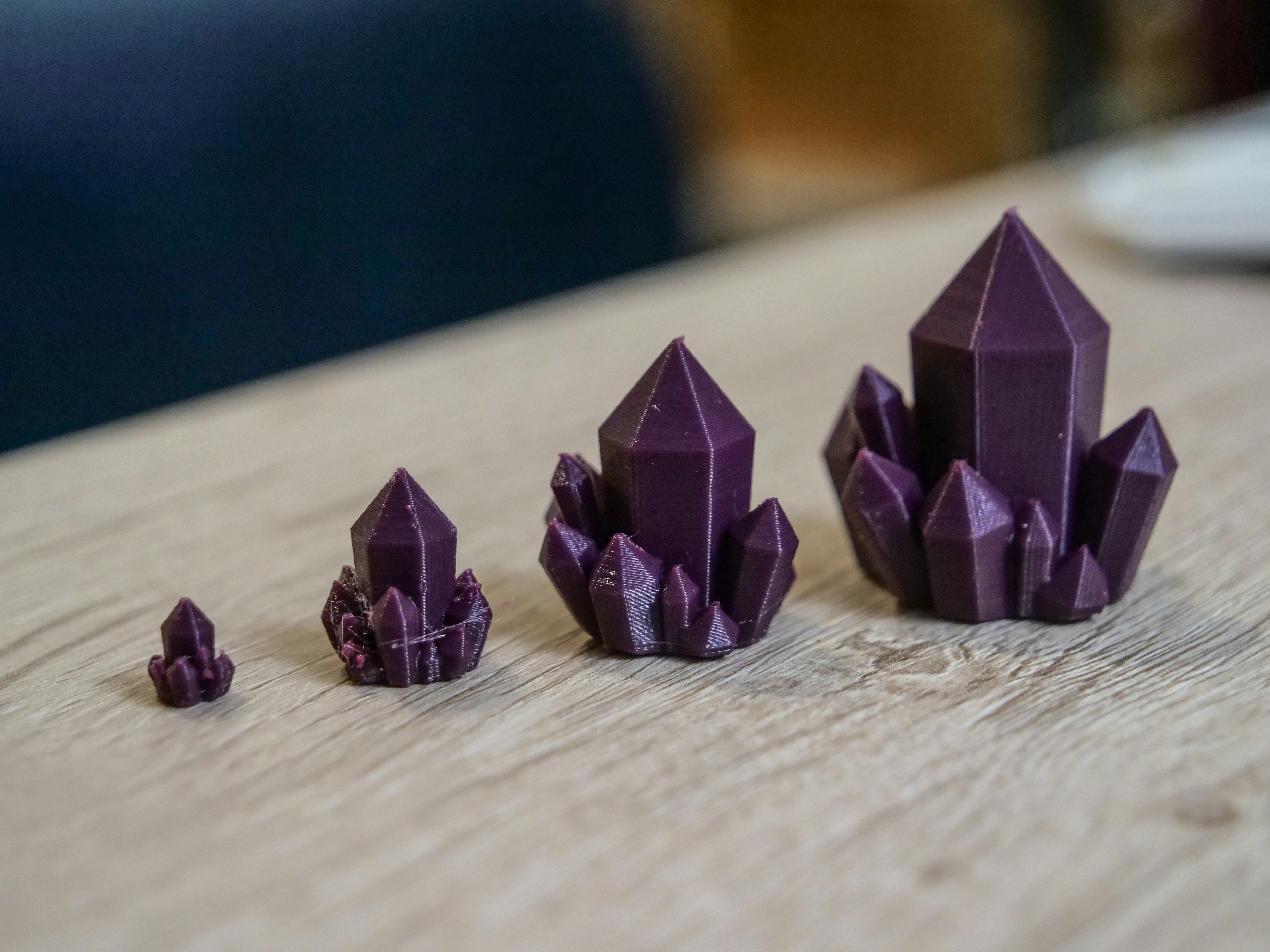 Four purple crystal clusters of increasing size.