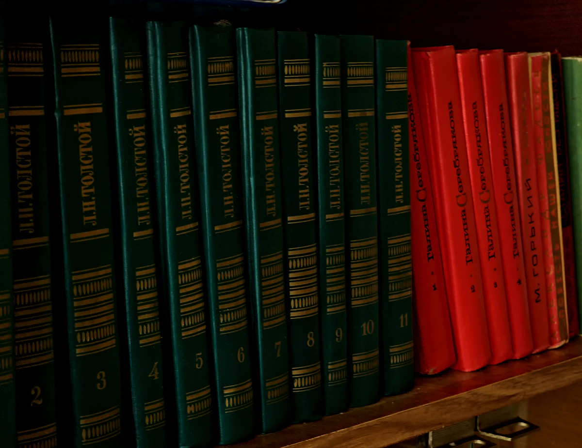 Gold-lettered hardcover spines on a private library shelf