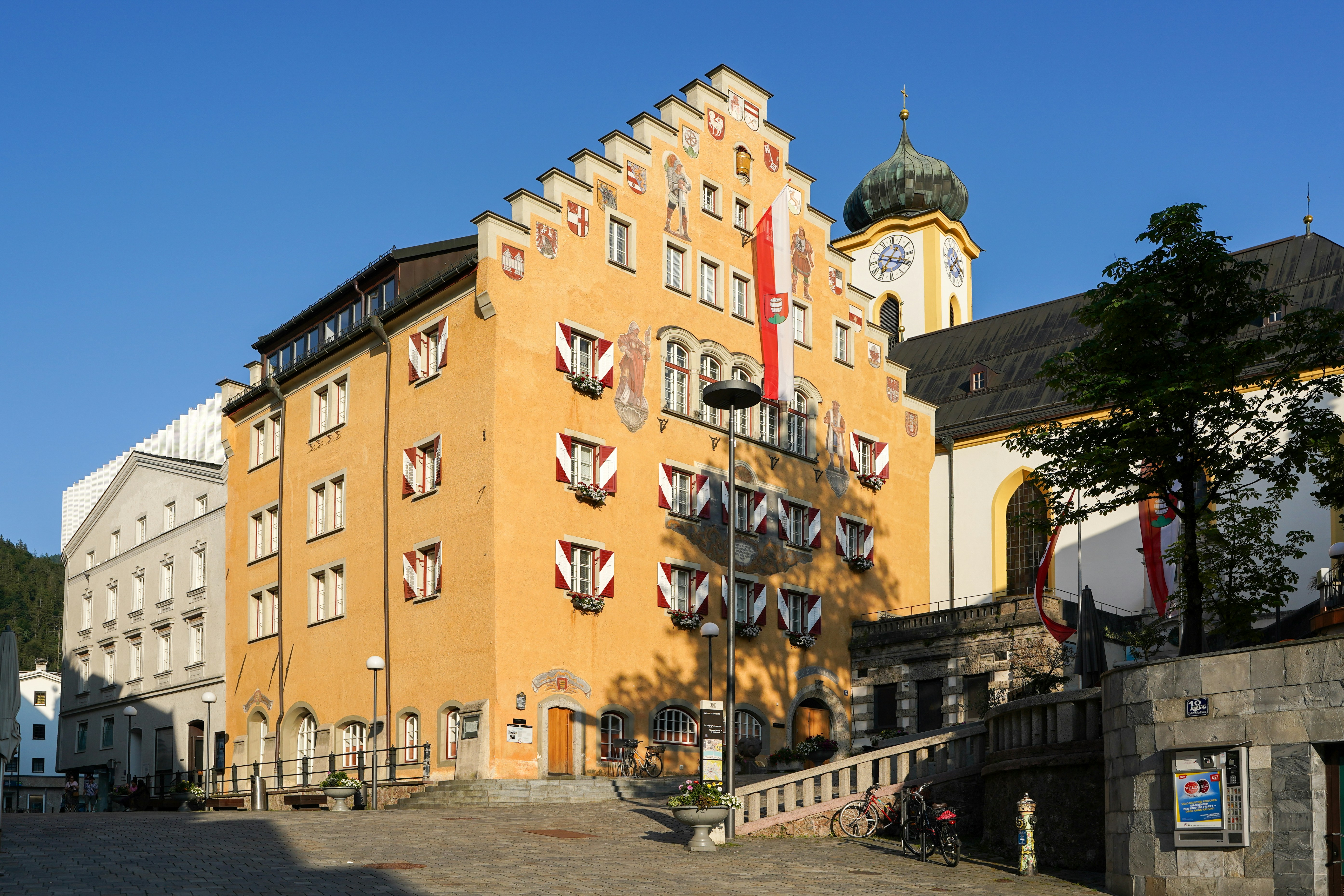Historic yellow building with ornate windows and church spire.