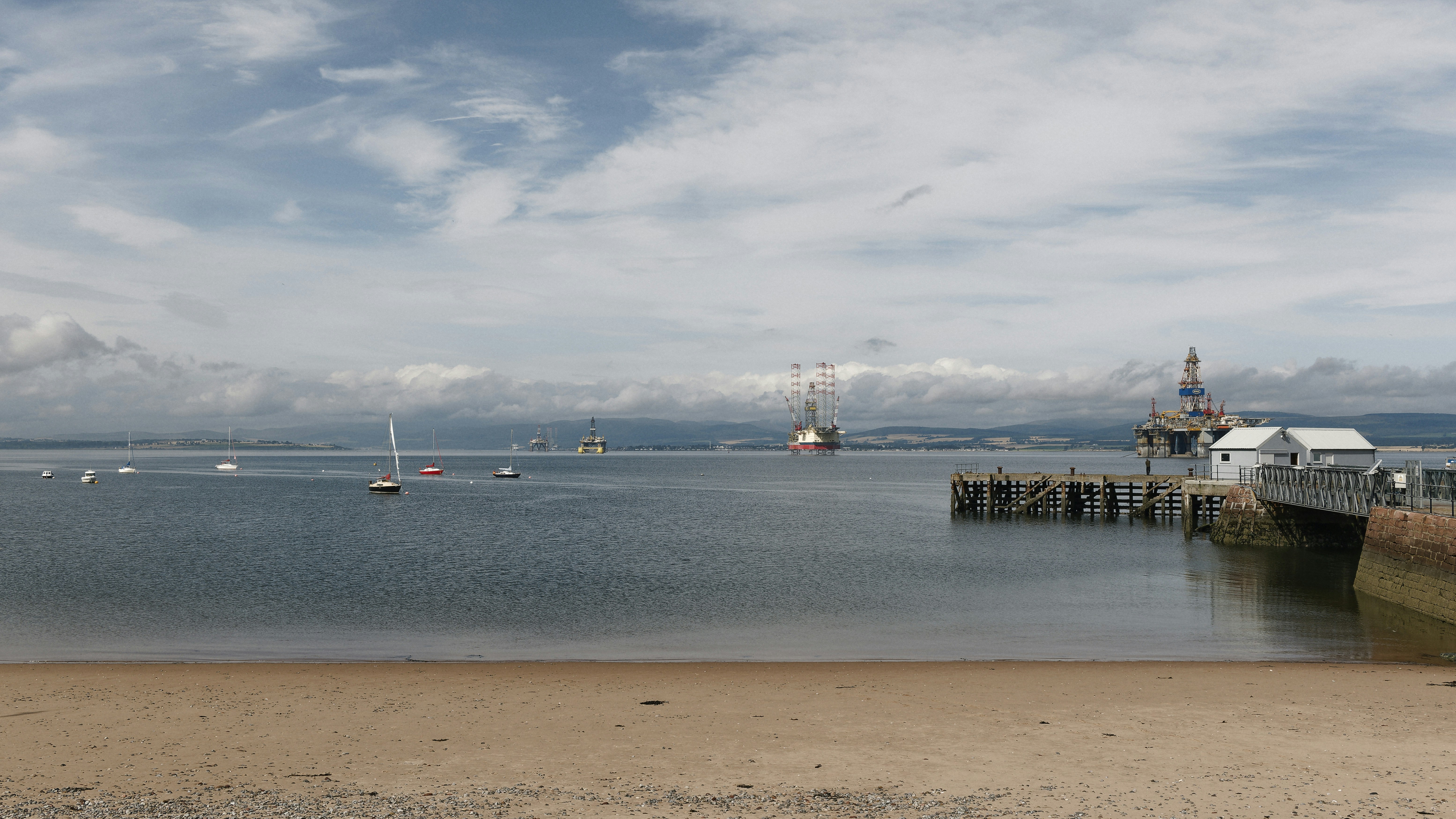 Sailboats and a pier on a calm sea