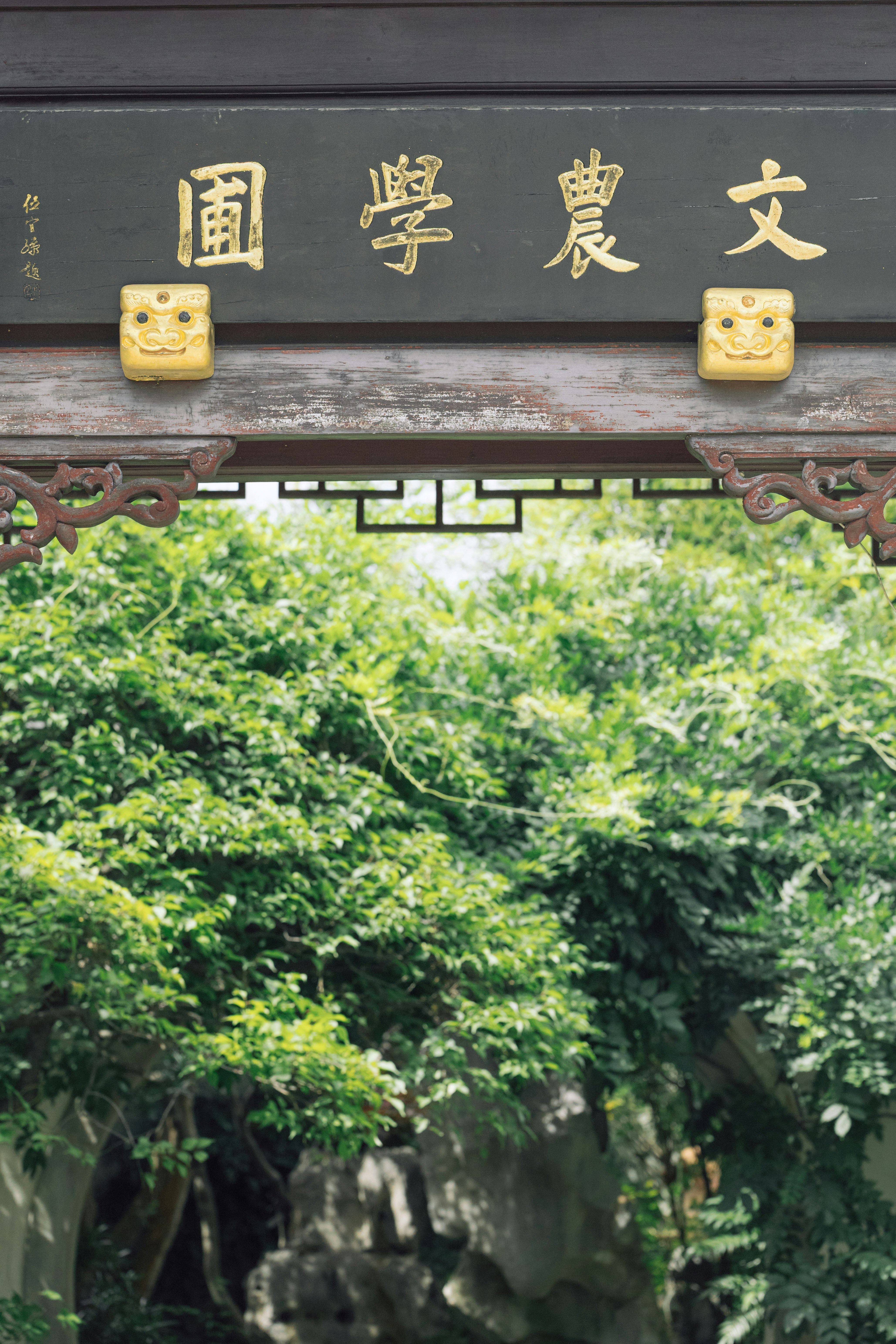 Traditional chinese archway with lush greenery beyond