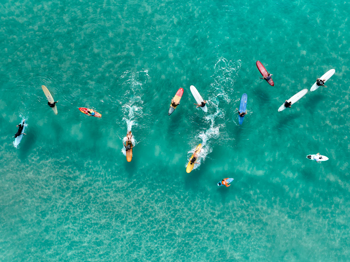 Paddleboarders enjoying clear turquoise ocean water from an aerial perspective