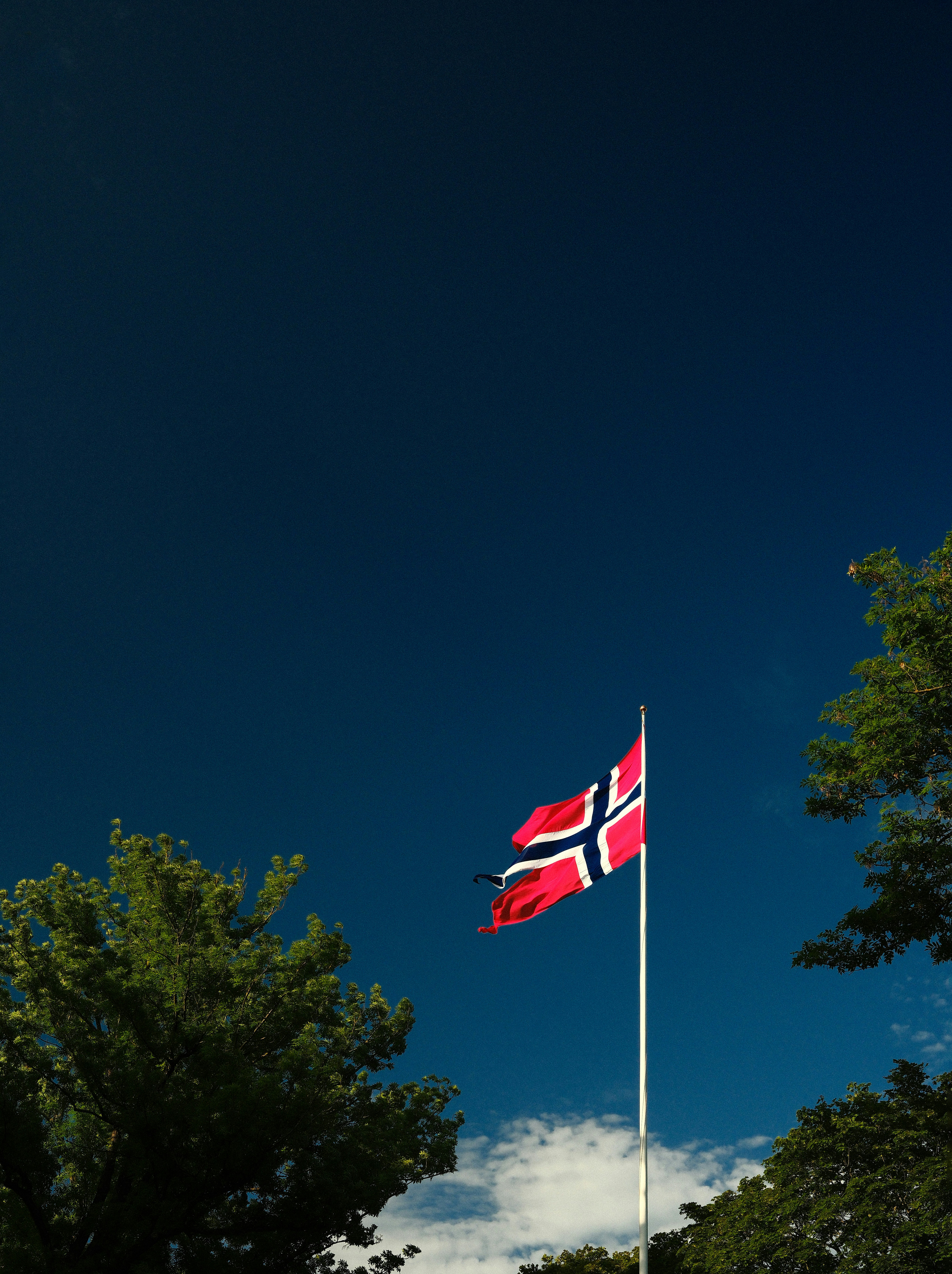 Bandeira norueguesa voando contra um céu azul claro