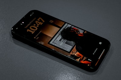 Smartphone displaying the time and a reflection