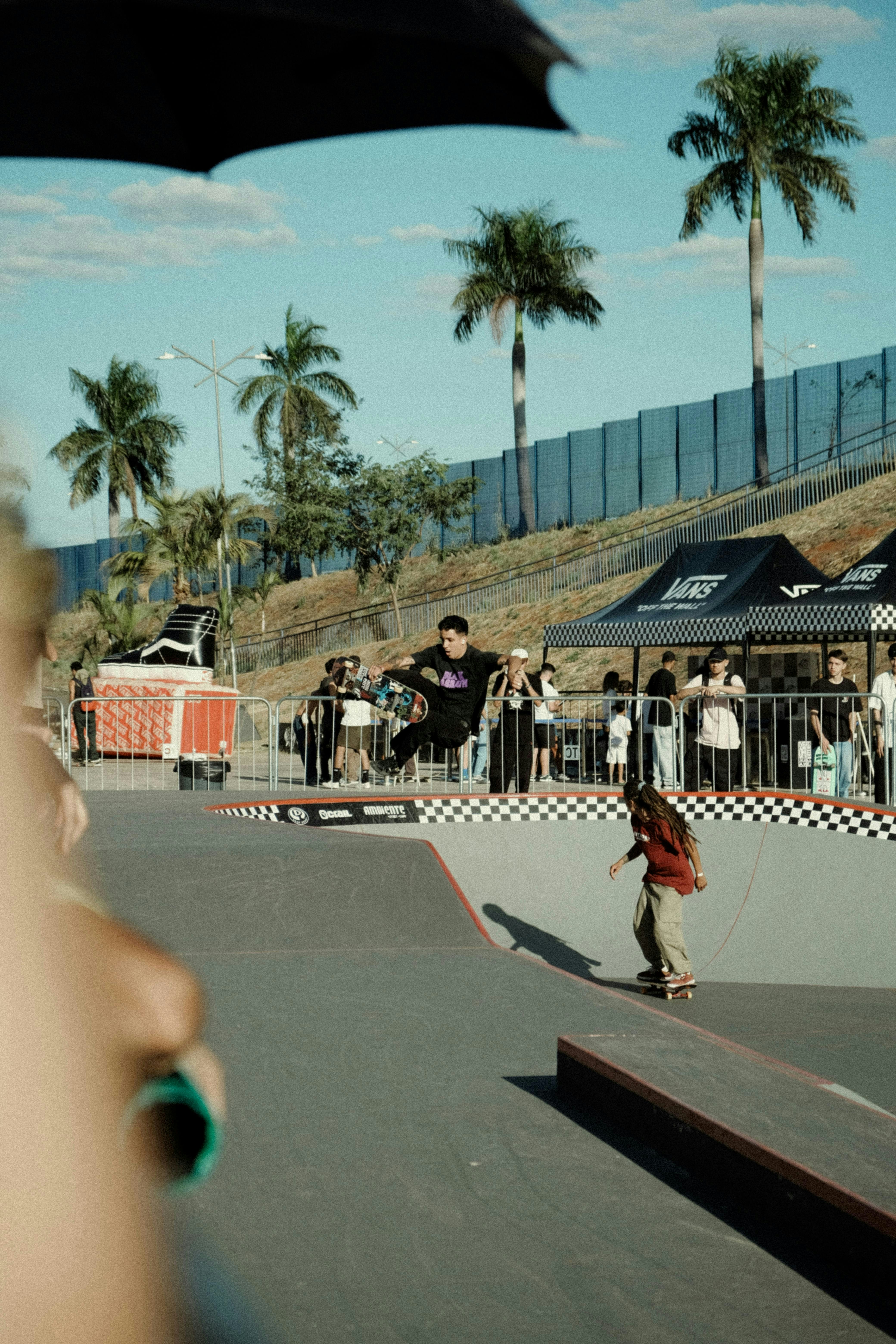 Des skateurs exécutent des figures lors d’un événement extérieur ensoleillé.