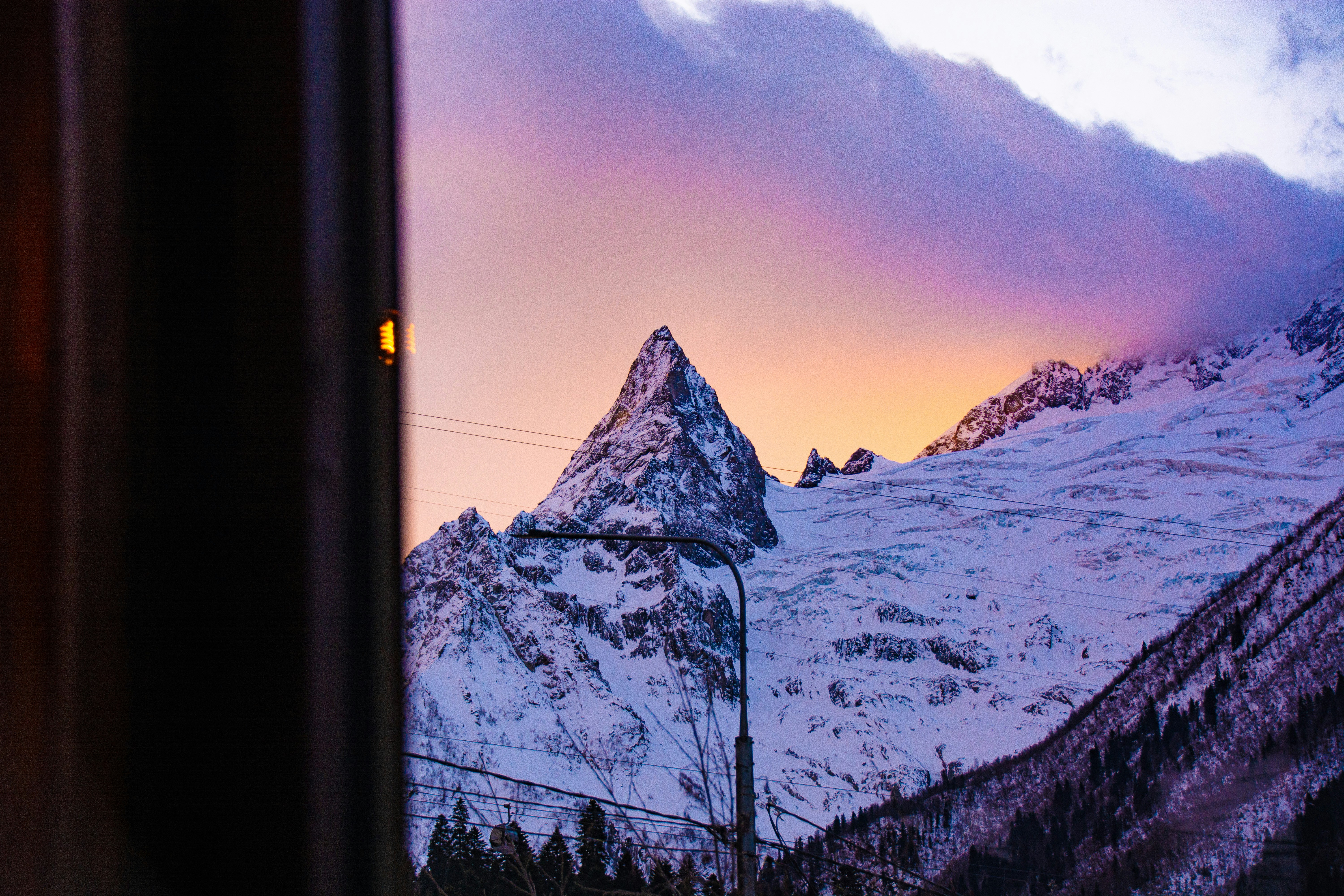 Snowy mountain peak at sunset with purple clouds