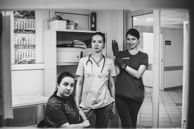 Three medical professionals posing in a hospital hallway.